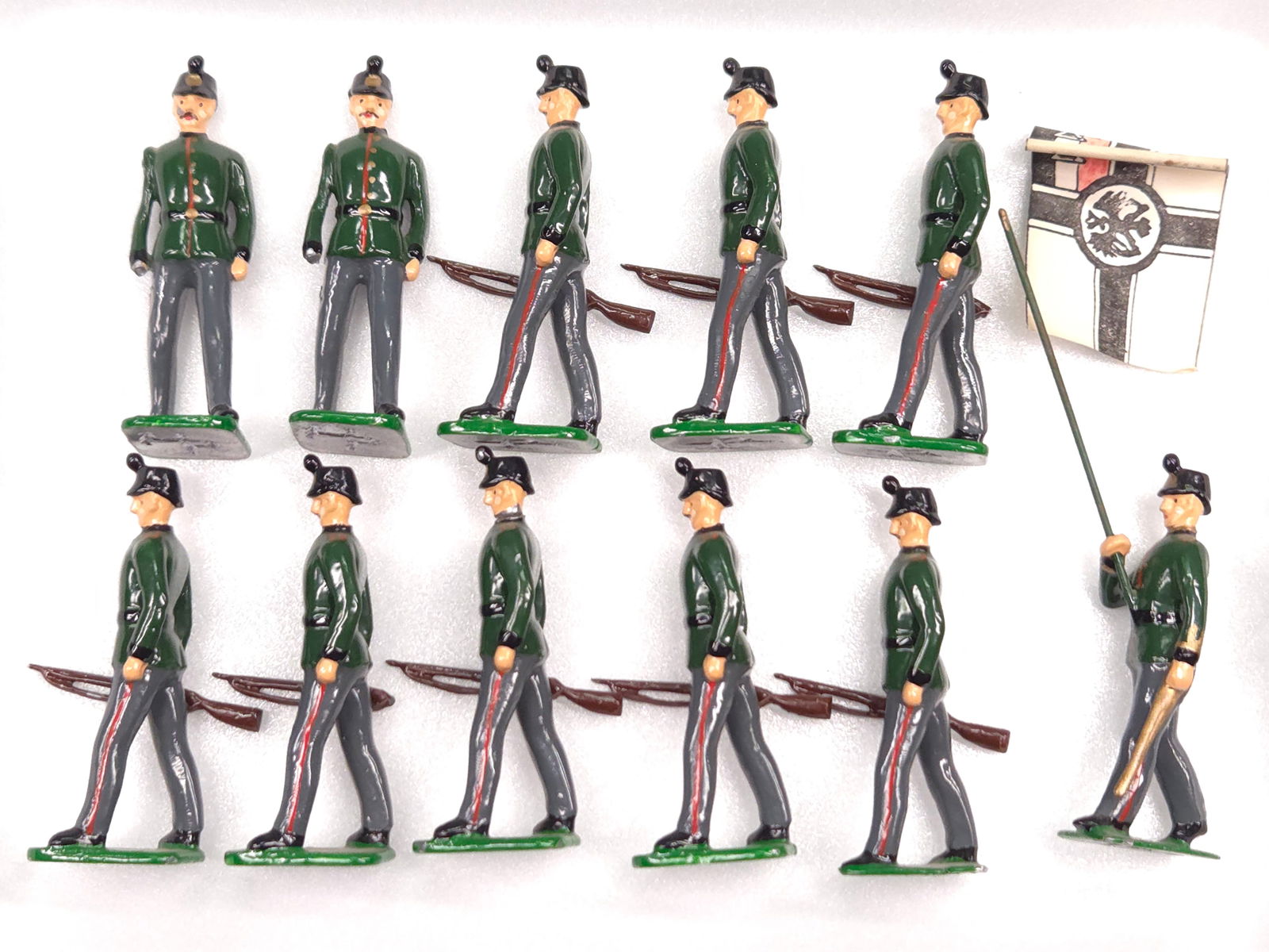 SET OF 11 WWI IMPERIAL GERMAN RIFLE CORPS. W/ FLAG: REMAINS IN VERY GOOD CONDITION, SHOWING ONLY SOME TYPICAL WEAR. TWO SOLDIERS WITH BROKEN HANDS & RIFLES.
