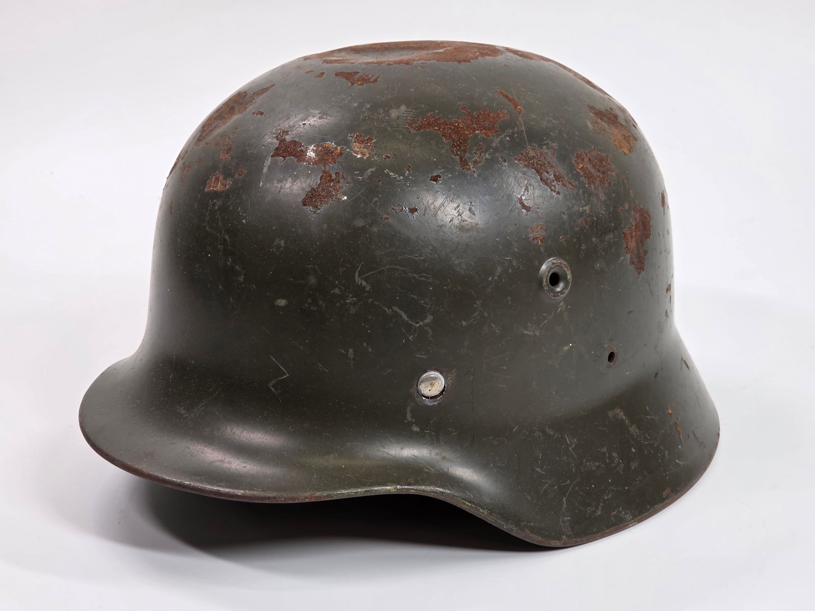 WWII GERMAN M40 MILITARY HELMET: REMAINS IN FAIR CONDITION, SHOWING TYPICAL WEAR. WEAR SPOTS THROUGHOUT AS SHOWN. SHOWS A FEW DENTS ON THE TOP.