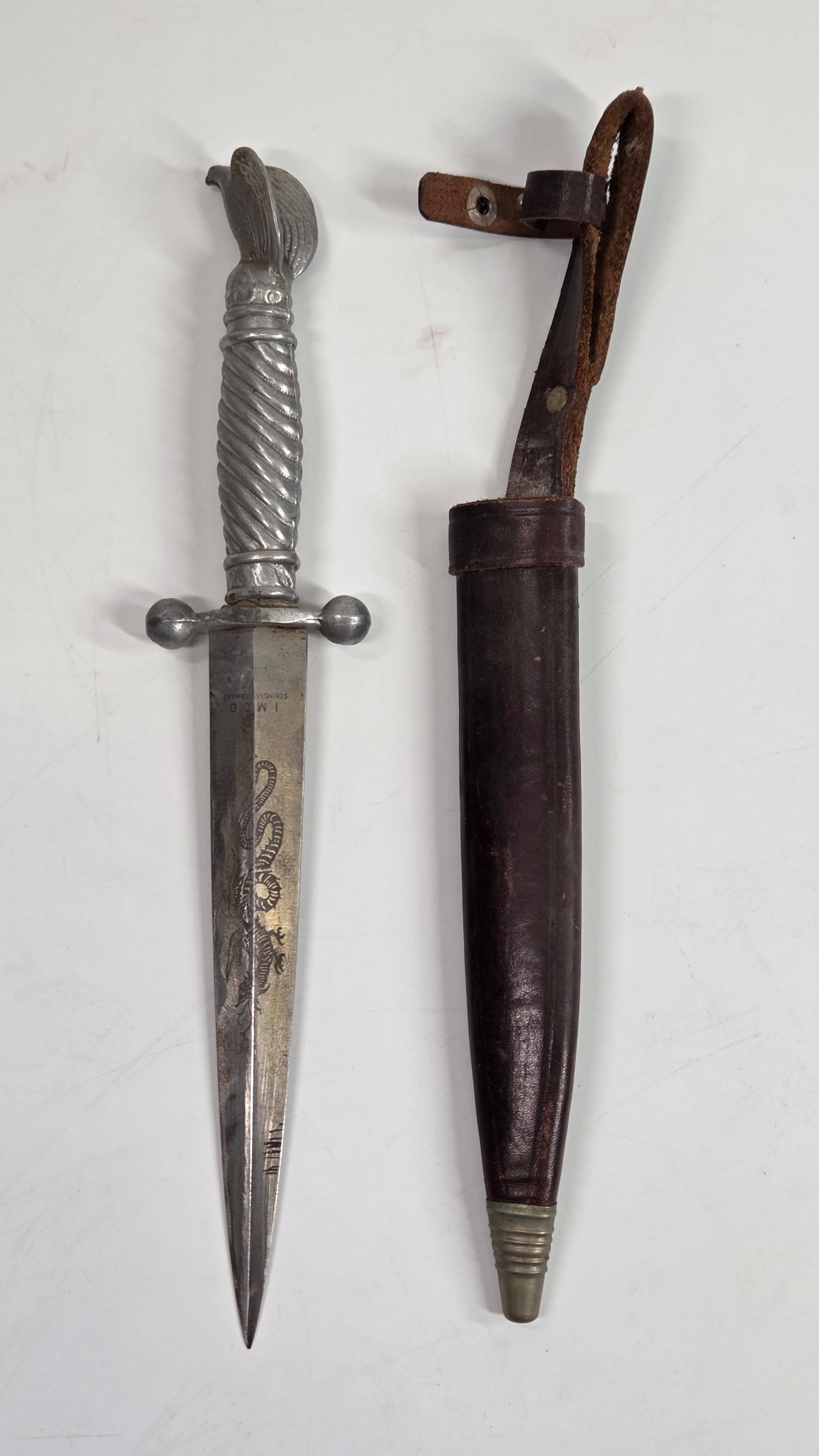 GERMAN WWII KORIUM HUNTING DAGGER: REMAINS IN GOOD CONDITION, SHOWING SOME TYPICAL WEAR. LEATHER SHEATH IN GOOD CONDITION, SHOWING TYPICAL WEAR.