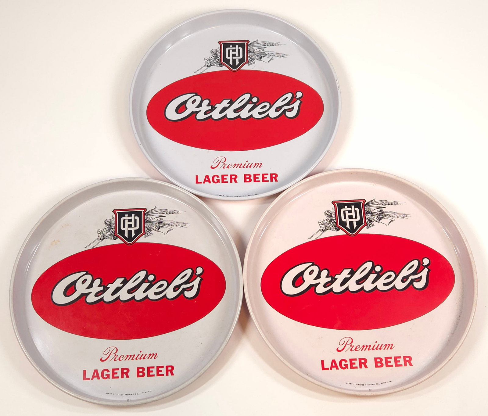 3) ORTLIEB'S LAGER BEER ADVERTISING TRAY: ALL REMAIN IN GOOD CONDITION, SHOWING ONLY SOME MINIMAL WEAR.