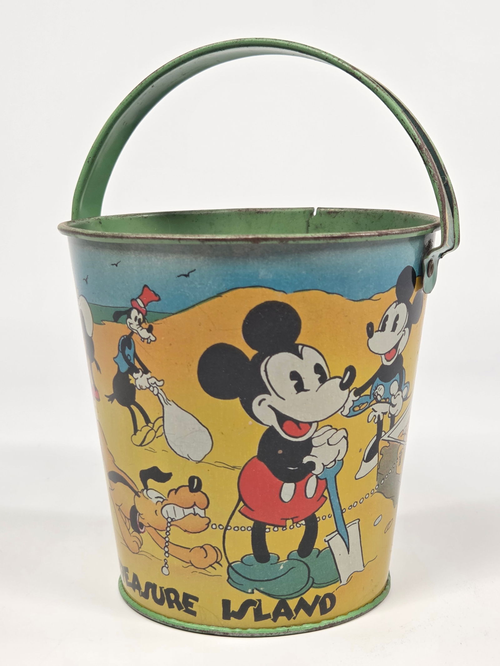 OHIO ART WALT DISNEY TREASURE ISLAND SAND BUCKET: REMAINS IN GOOD CONDITION, SHOWING SOME TYPICAL WEAR.