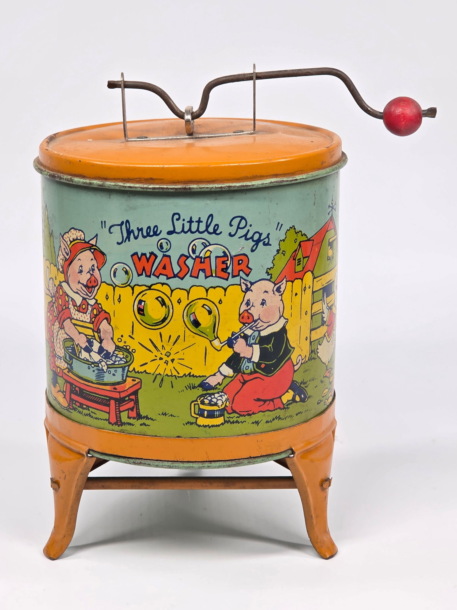 J. CHEIN TIN LITHO THREE LITTLE PIGS WASHER: REMAINS IN GOOD CONDITION, SHOWING SOME TYPICAL WEAR.