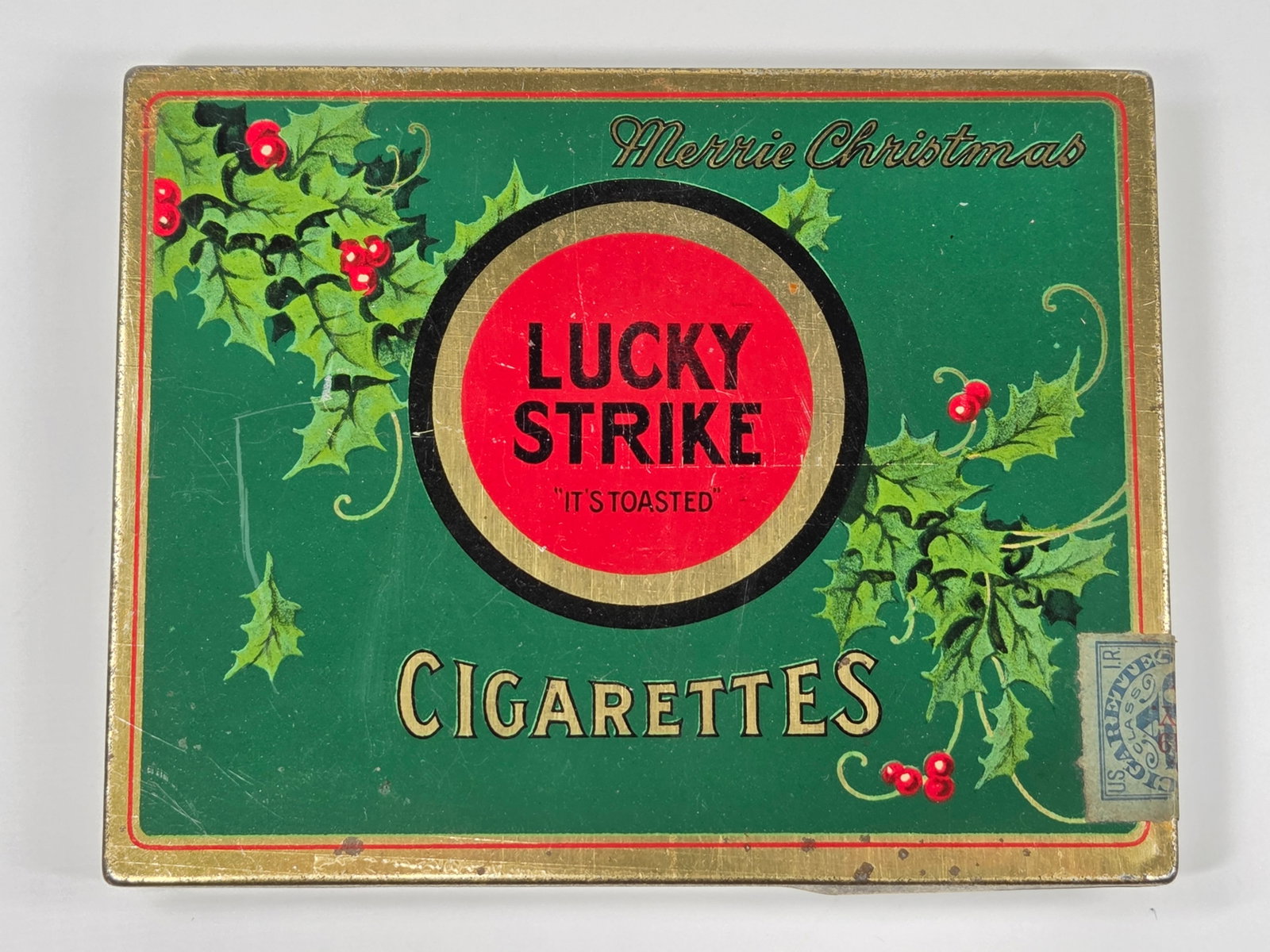 LUCKY STRIKE MERRIE CHRISTMAS CIGARETTE TIN: REMAINS IN GOOD CONDITION, SHOWING SOME TYPICAL WEAR.