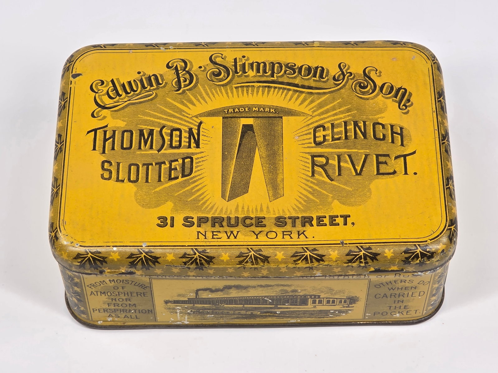 EDWIN B. STIMPSON & SON SLOTTED RIVET ADVERTISING TIN: REMAINS IN GOOD CONDITION, SHOWING SOME TYPICAL WEAR.