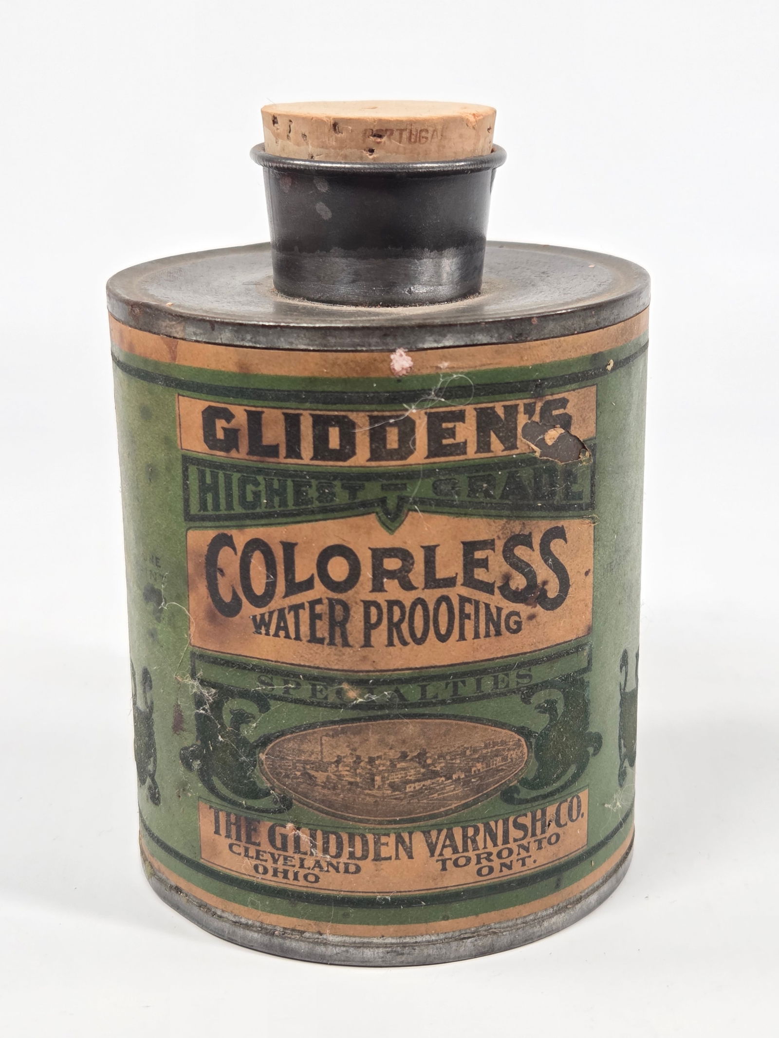 GLIDDEN VARNISH CO. WATERPROOFING TIN W/ PAPER LABEL: LABEL REMAINS IN GOOD CONDITION, SHOWING SOME STAINING AND SMALL TEARS. TIN REMAINS IN GOOD CONDITION. REPLACED CORK