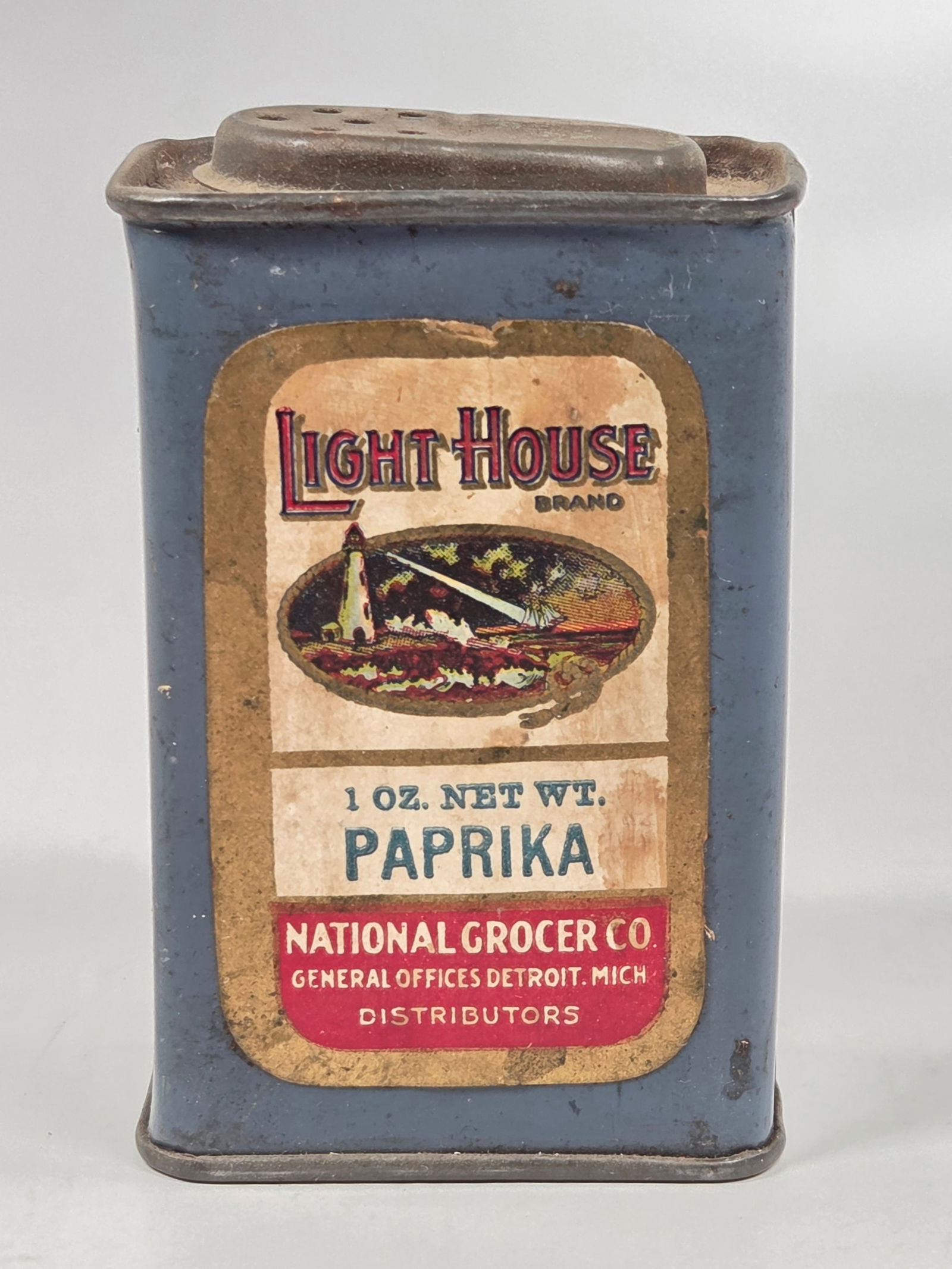 NATIONAL GROCER CO. LIGHTHOUSE BRAND 1 OZ. PAPRIKA SPICE TIN: REMAINS IN FAIR TO GOOD CONDITION, SHOWING SOME WEAR TO PAPER LABEL.