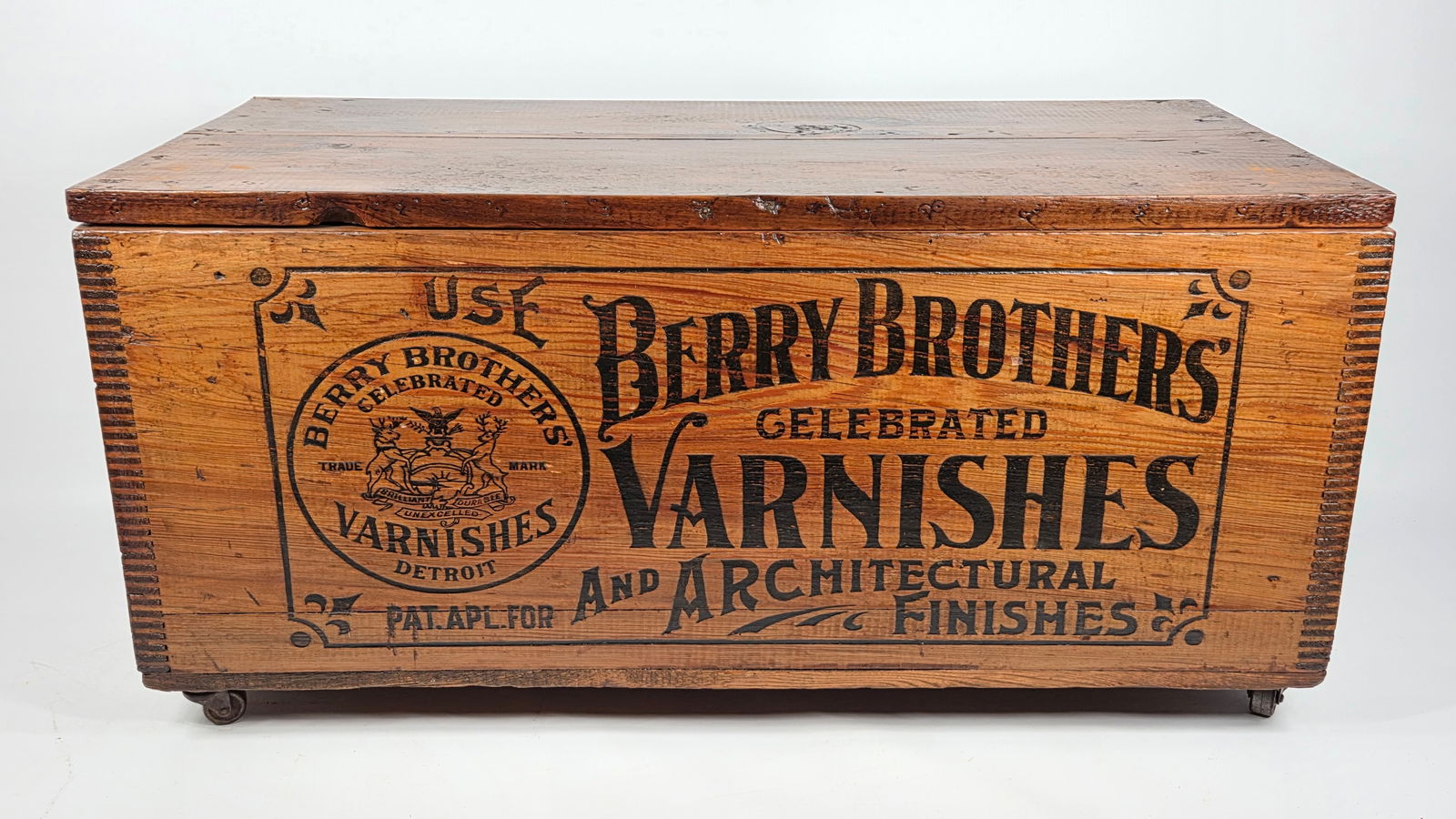 BERRY BROTHERS VARNISHES WOOD BOX W/ LID: REMAINS IN GOOD CONDITION, SHOWING SOME TYPICAL USAGE WEAR. CASTOR WHEELS ADDED. SIDES AND LID HAVE BEEN SHELLACKED.