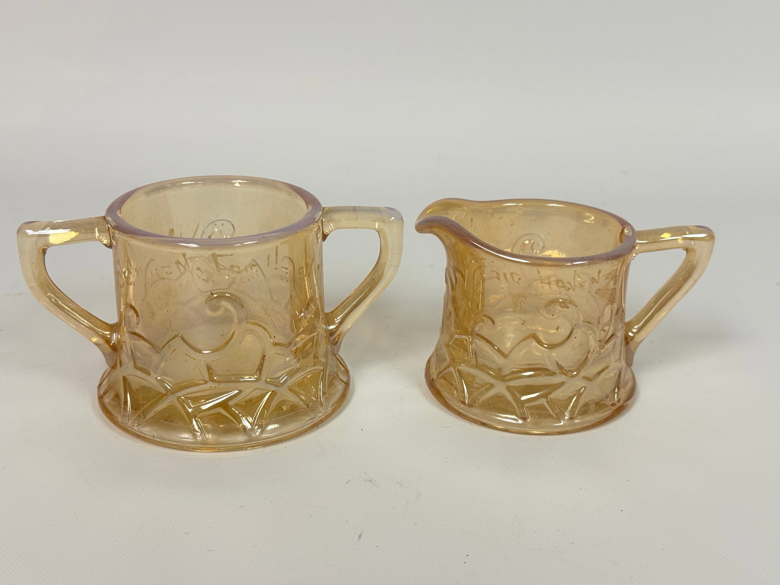 PEACH OPALESCENT NEW YORK WORLD'S FAIR CREAM & SUGAR SET: SET REMAINS IN GOOD CONDITION, NO CHIPS OR CRACKS. WORLD'S FAIR WRITING FADED.
