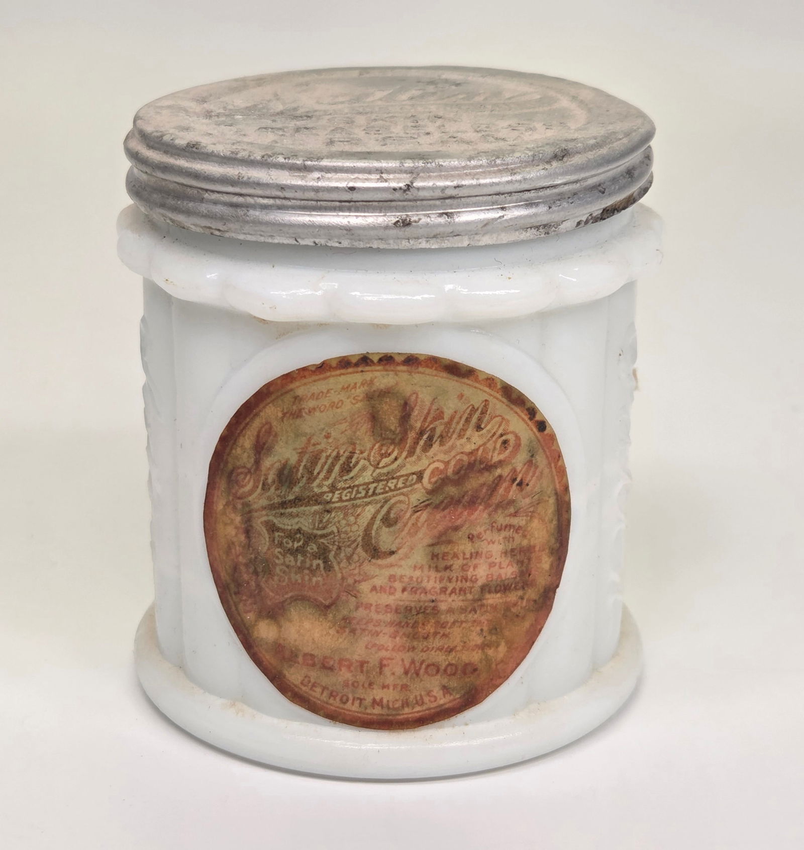 SATIN SKIN COLD CREAM MILK GLASS JAR: REMAINS IN GOOD CONDITION, SHOWINGS OME TYPICAL WEAR. LABEL STAINED AND FADED.