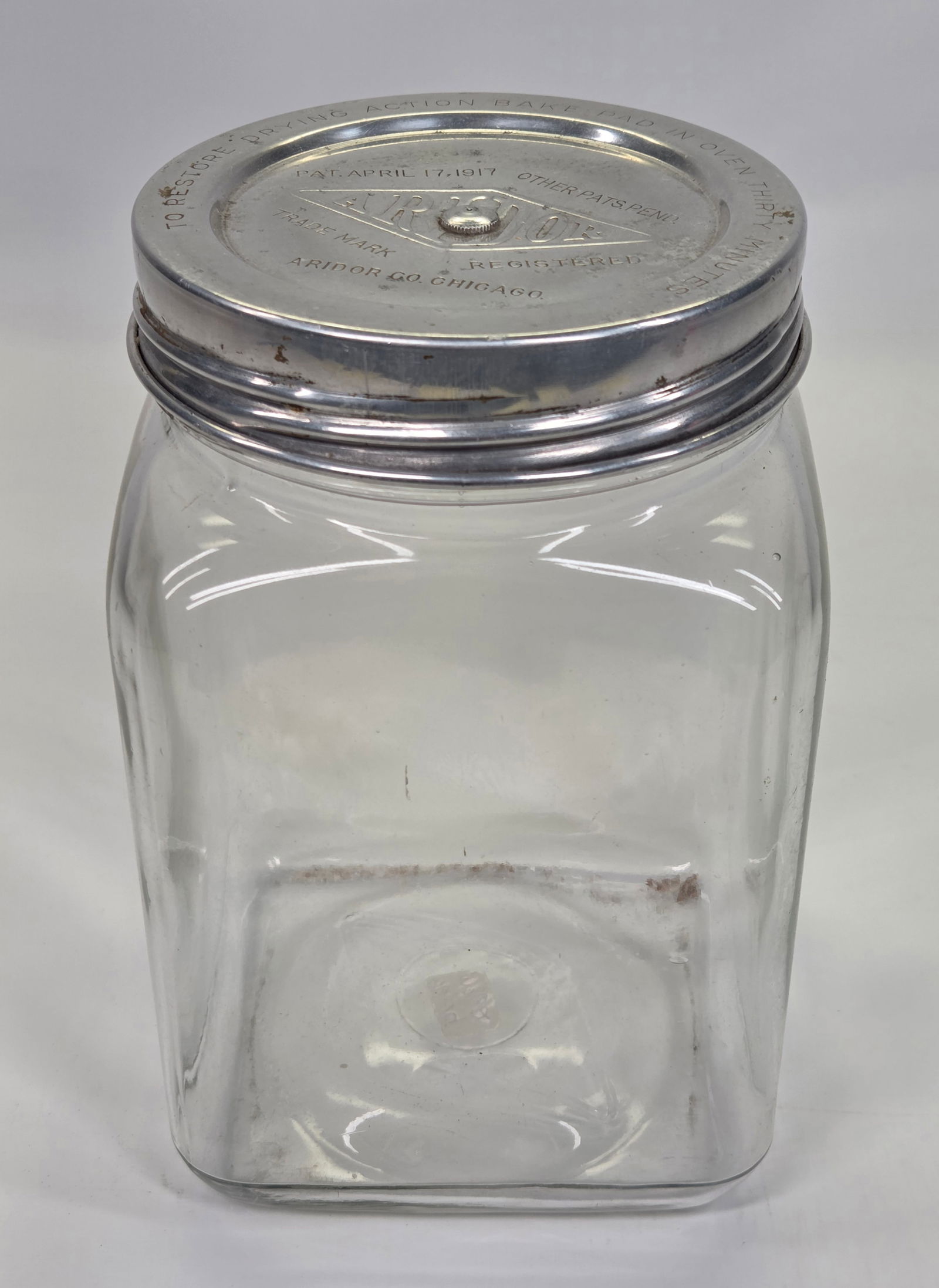ANTIQUE SCHUST'S GLASS STORE JAR W/ ARIDOR CO. LID: REMAINS IN GOOD CONDITION, SHOWING SOME TYPICAL WEAR.