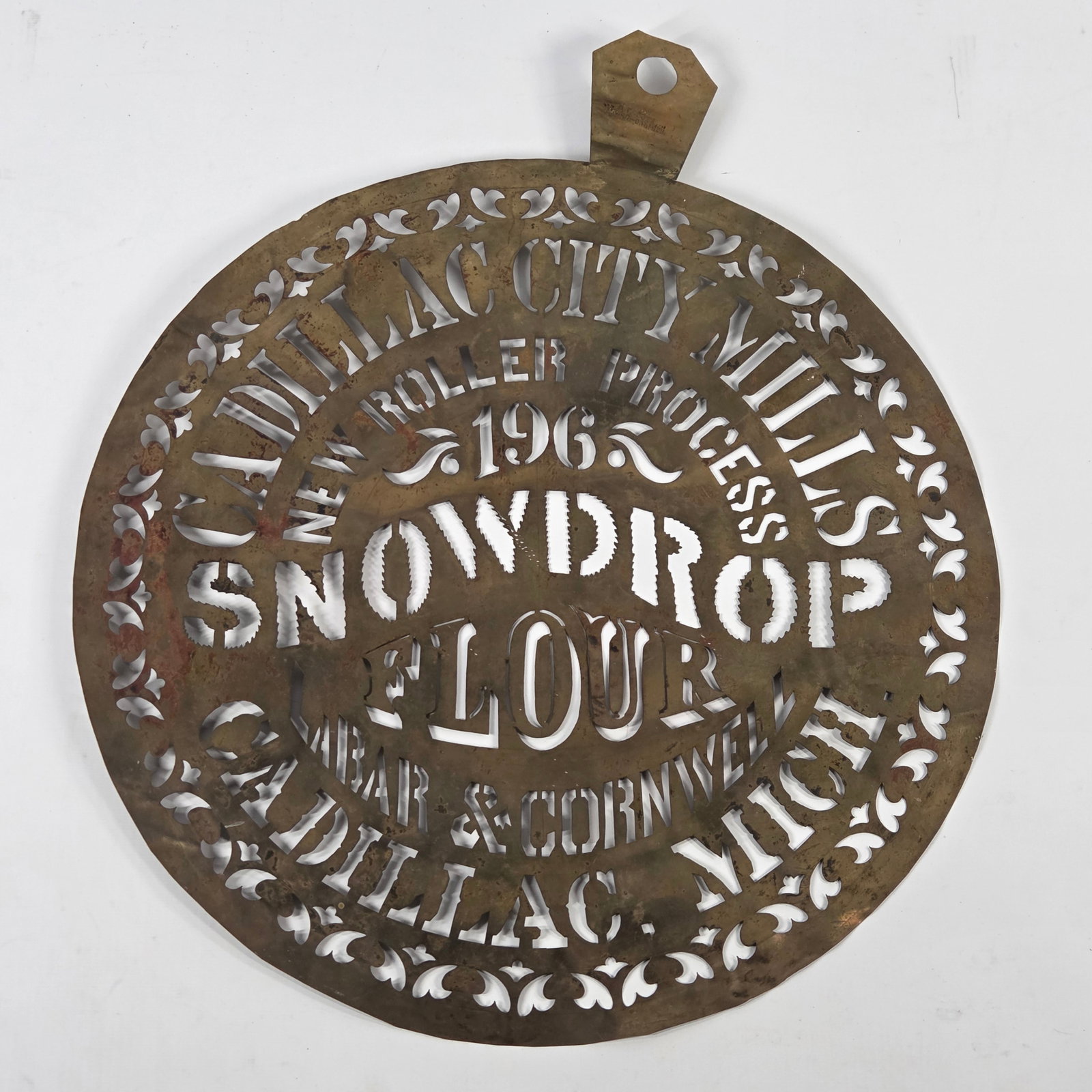 CADILLAC CITY MILLS SNOWDROP FLOUR BRASS STENCIL: REMAINS IN GOOD CONDITION, SHOWING SOME TYPICAL USAGE WEAR.