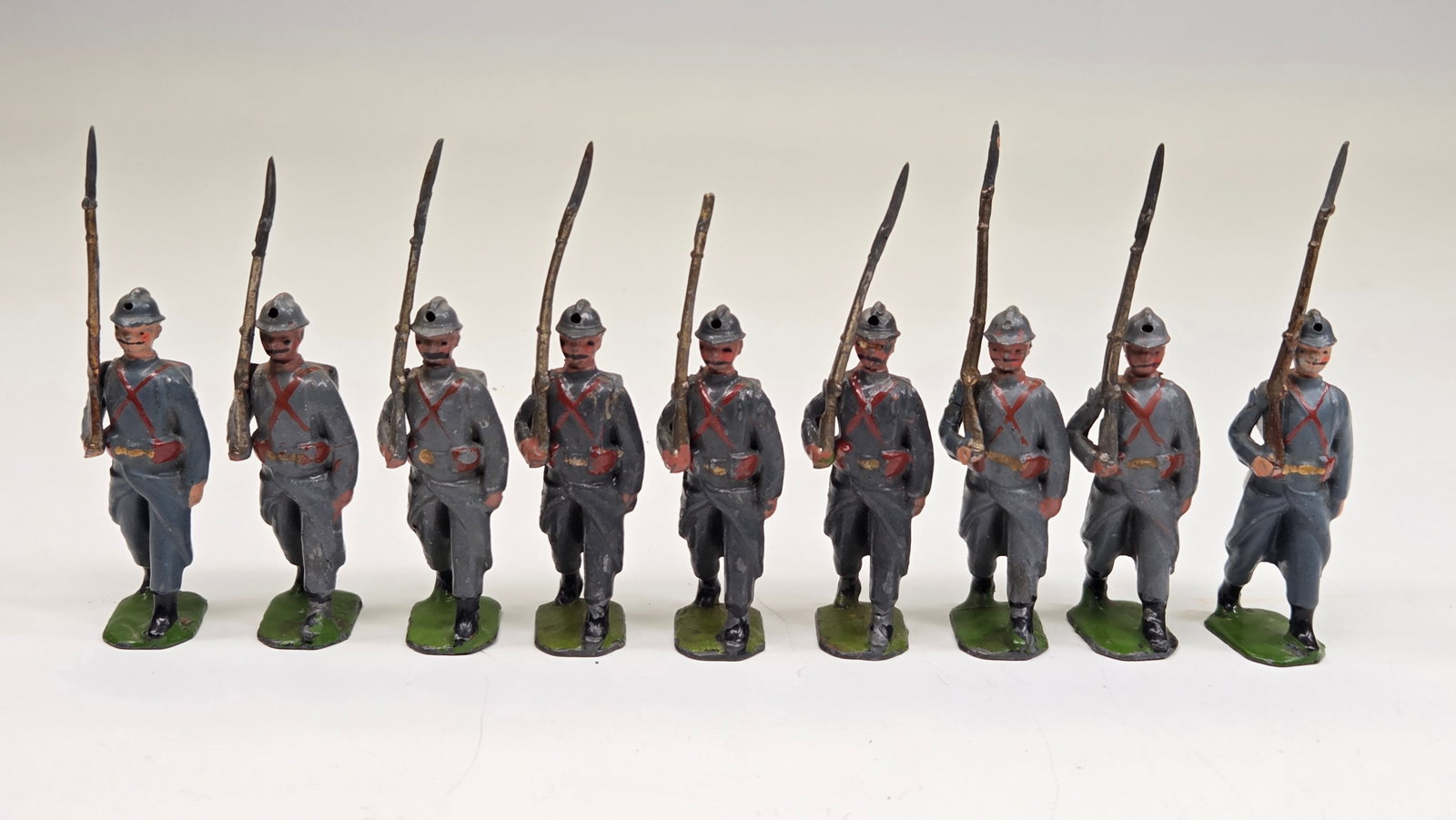SET OF 9 BRITAIN LEAD SOLDIERS: ALL REMAIN IN GOOD CONDITION, SHOWING SOME TYPICAL PAINT WEAR. ONE SOLDIER WITH BROKEN RIFLE TIP.