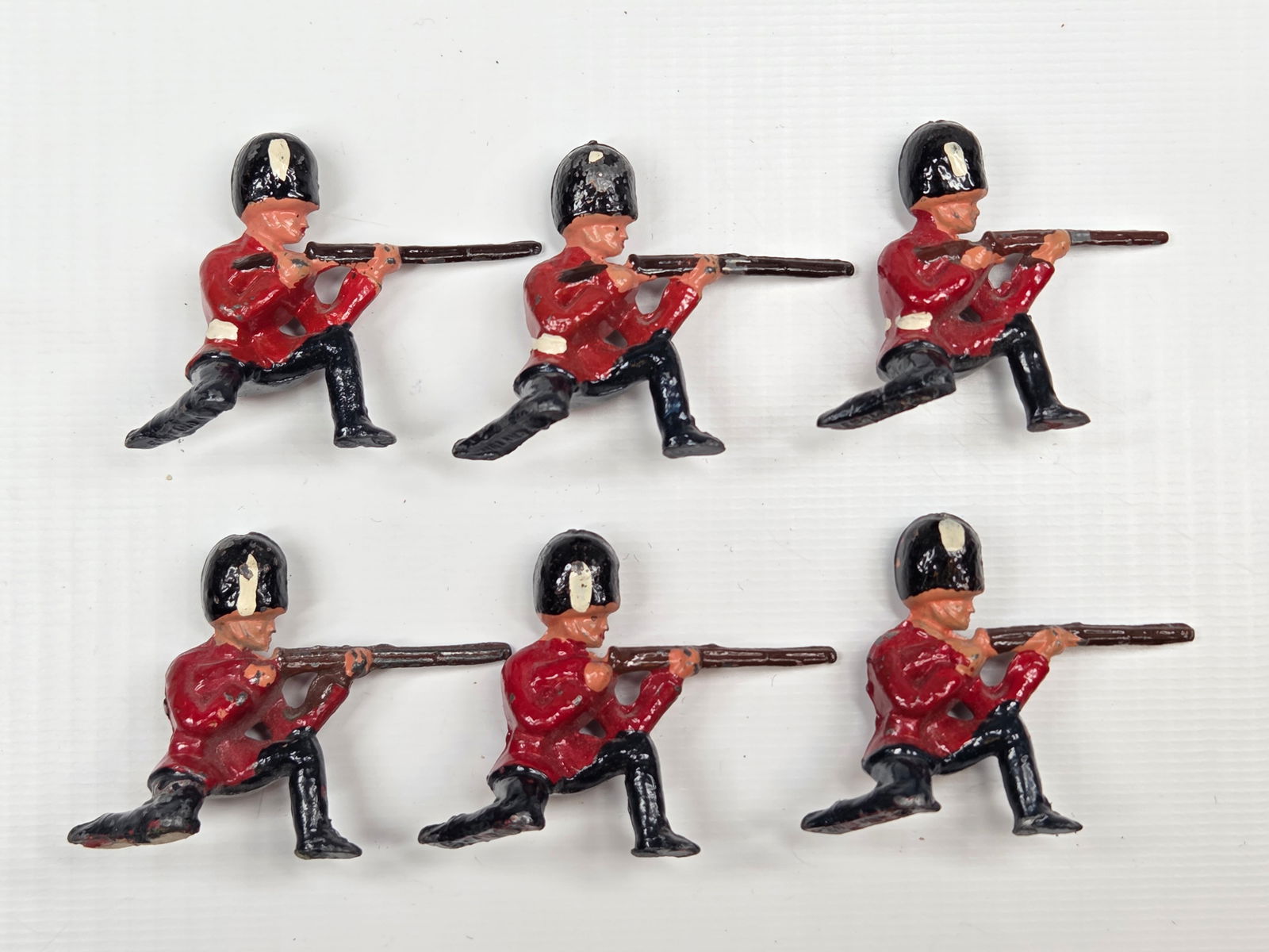 SET OF 6 BRITAINS BRITISH ROYAL GUARDS KNEELING FIRING: ALL REMAIN IN FAIR TO GOOD CONDITION, SHOWING SOME TYPICAL PAINT WEAR.