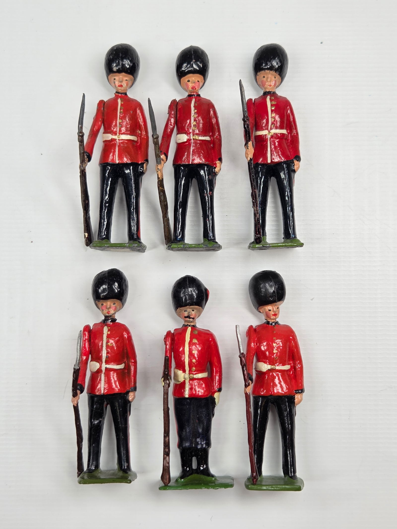 SET OF 6 BRITAINS COLDSTREAM GUARDS: ALL REMAIN IN GOOD CONDITION, SHOWING SOME TYPICAL PAINT WEAR. 2 WITH BROKEN RIFLE TIPS.