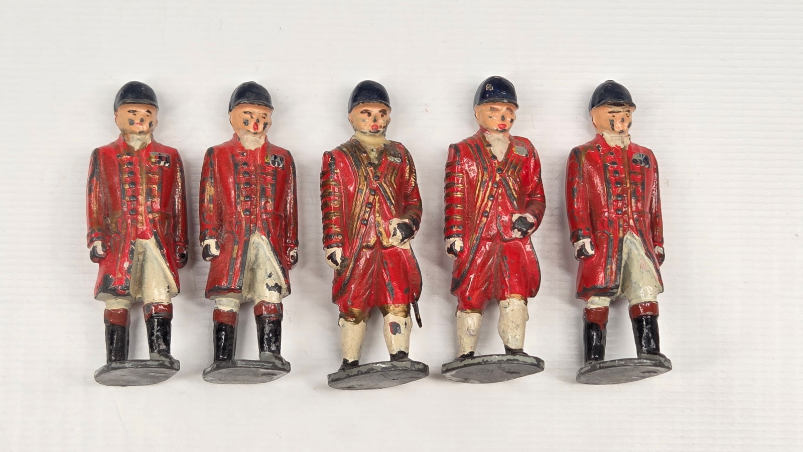 5) VINTAGE BRITAIN FOOTMEN OF THE STATE COACH: ALL REMAIN IN FAIR TO GOOD CONDITION, SHOWING SOME PAINT WEAR. SOLDIER IN THE MIDDLE HAS BROKEN / REPAIRED HEAD.