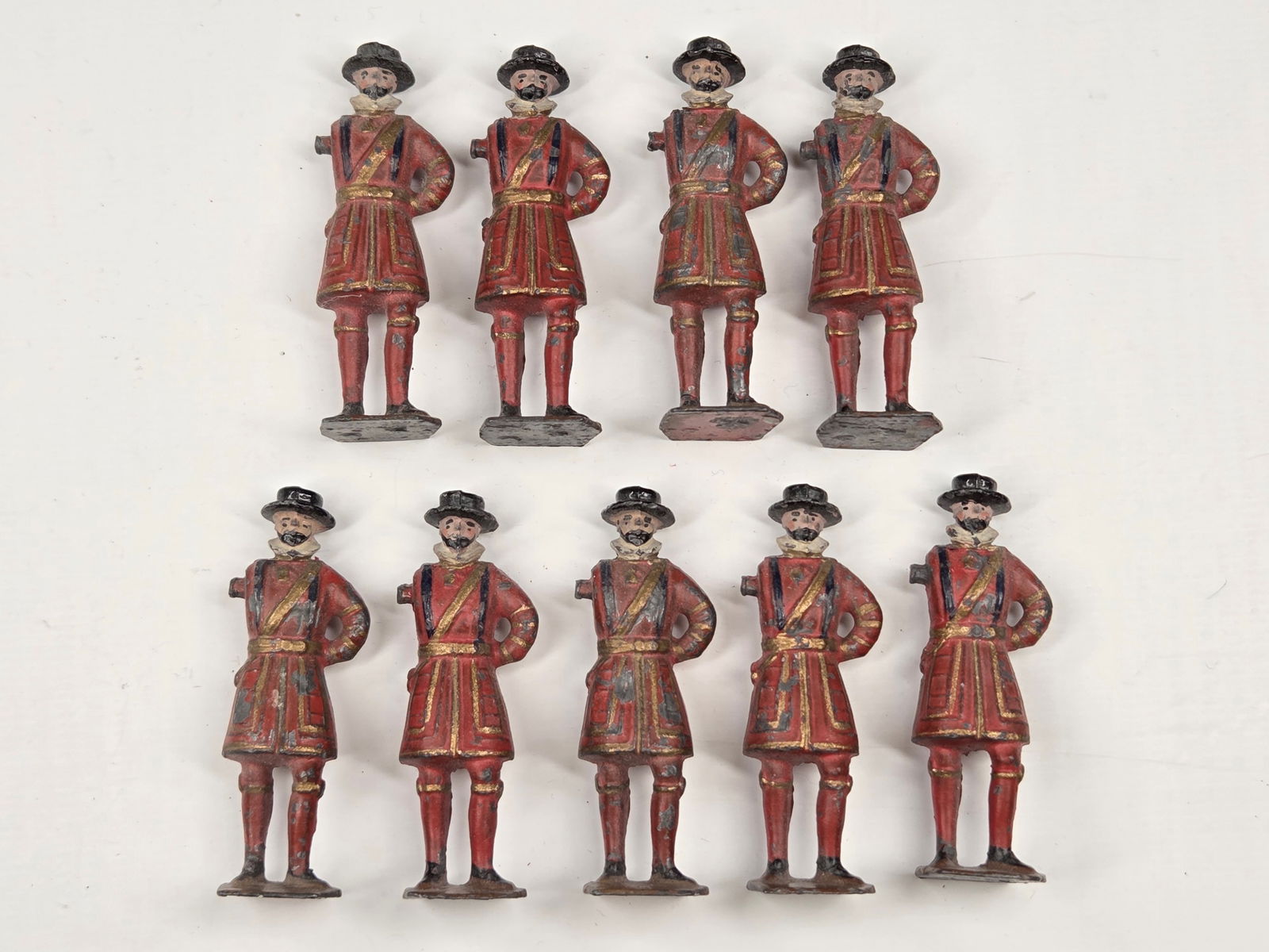 9) VINTAGE BRITAINS BEEFEATER FIGURES: ALL REMAIN IN FAIR CONDITION, SHOWING PAINT WEAR. ALL MISSING ARM.