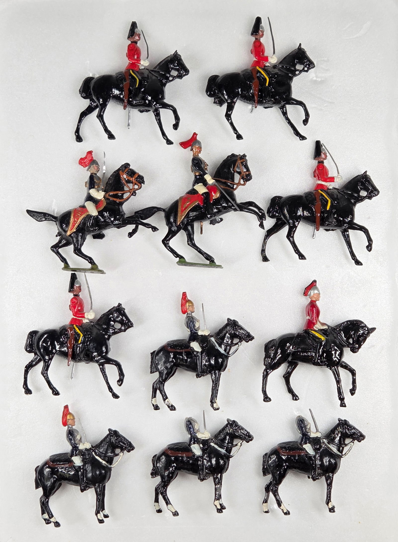 11) VARIOUS VINTAGE BRITAINS MOUNTED LEAD SOLDIERS: ALL REMAIN IN FAIR TO GOOD CONDITION, SHOWING SOME TYPICAL PAINT WEAR. TWO SOLDIERS WITH BROKEN / MISSING HEADS. ONE HORSE WITH BROKEN LEG. BENDS TO SWORDS.