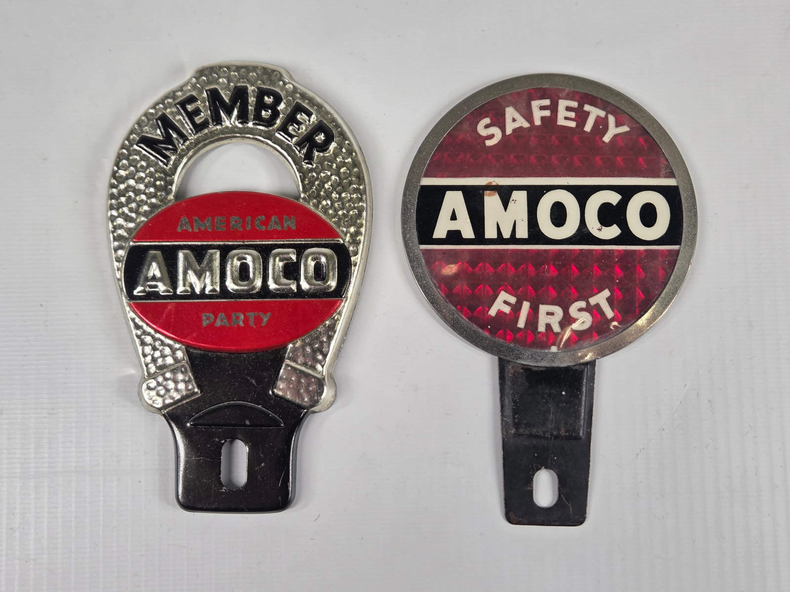 AMOCO SAFETY FIRST & MEMBER LICENSE PLATE TOPPERS: BOTH REMAIN IN GOOD CONDITION, SHOWING SOME LIGHT TYPICAL WEAR.
