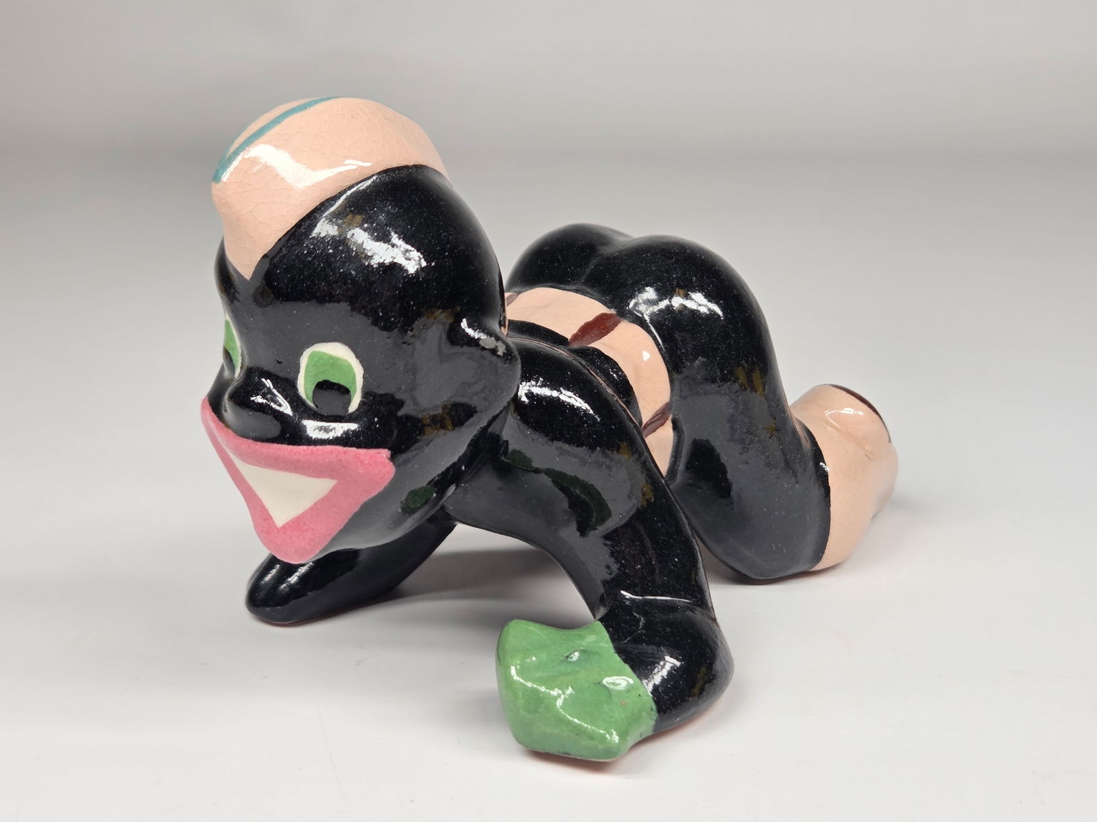 CERAMIC BLACK AMERICANA SOLDIER CRAWLING: REMAINS IN GOOD CONDITION, SHOWING SOME TYPICAL WEAR. NO CHIPS OR CRACKS.