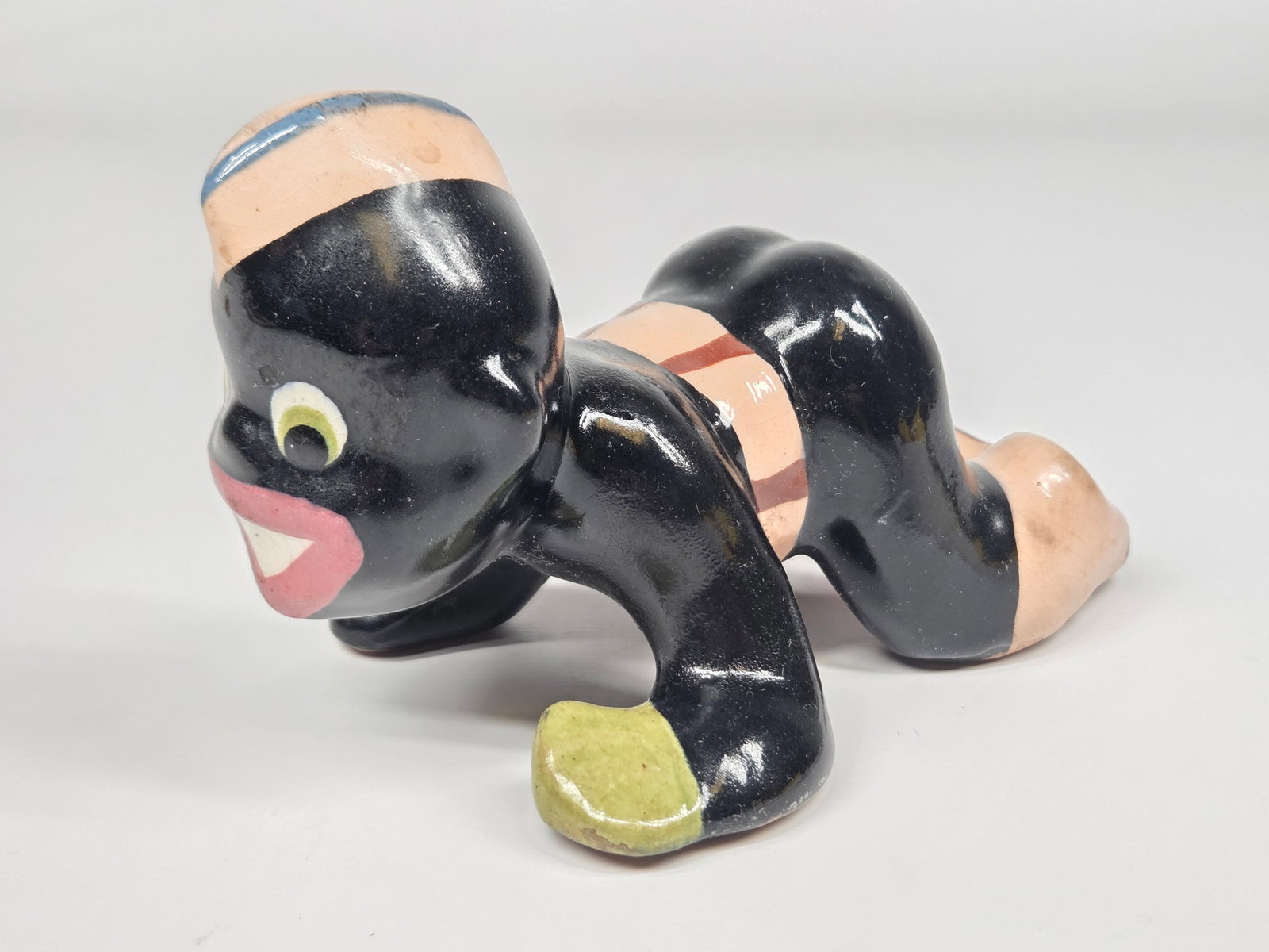 CERAMIC BLACK AMERICANA SOLDIER CRAWLING: REMAINS IN GOOD CONDITION, SHOWING SOME TYPICAL WEAR. NO CHIPS OR CRACKS.