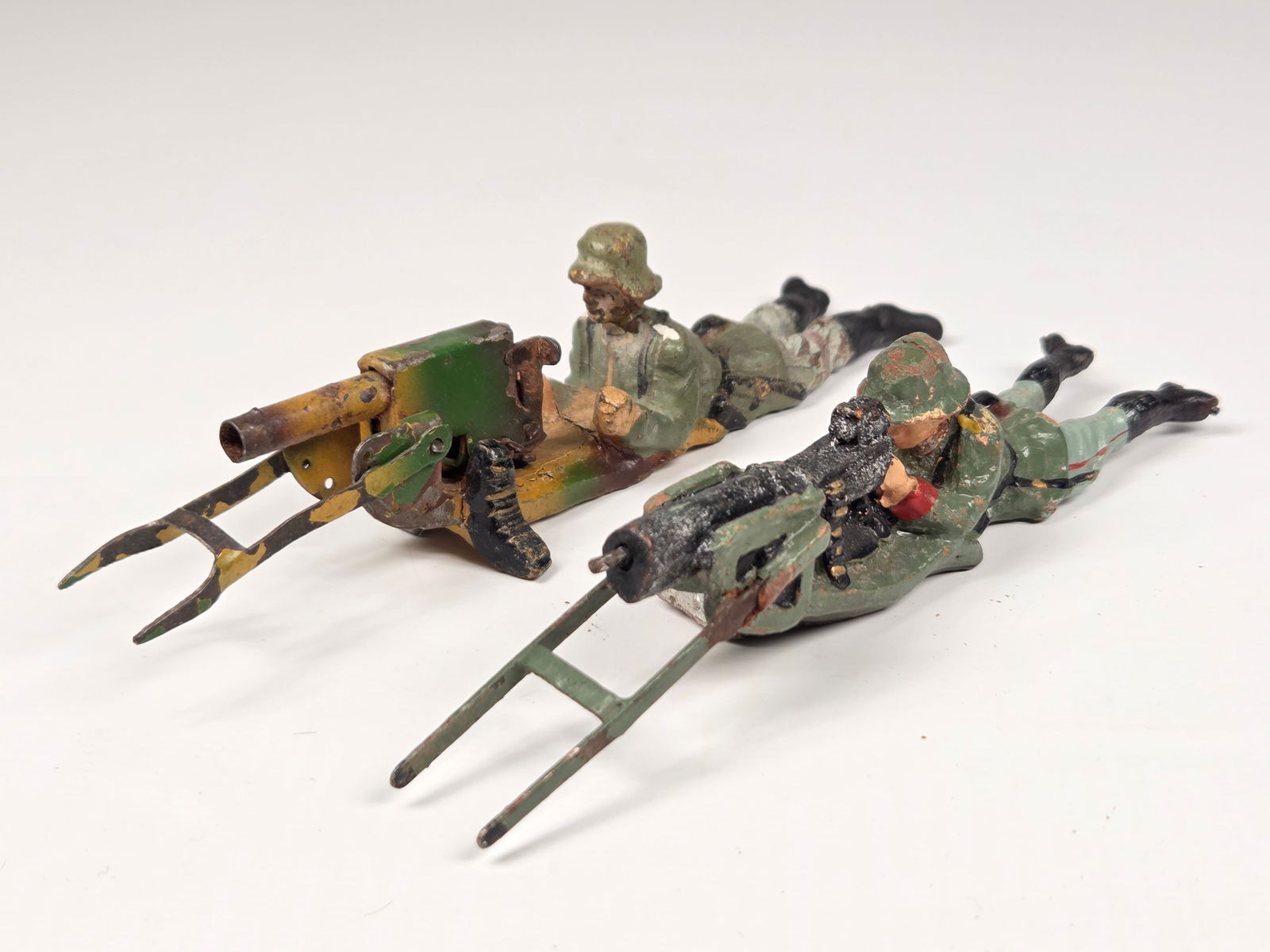 2) LINEOL GERMAN SOLDIERS W/ MACHINE GUNS: BOTH REMAIN IN FAIR CONDITION, SHOWING TYPICAL WEAR THROUGHOUT.
