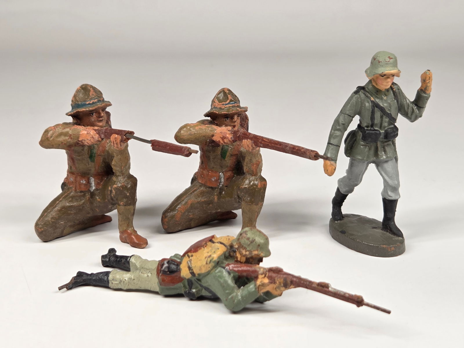 4) GERMAN COMPOSITION SOLDIERS: ALL REMAIN IN FAIR TO GOOD CONDITION, SHOWING TYPICAL WEAR. ALL RIFLES HAVE CRACK OR PIECE MISSING. STANDING SOLDIER WITH CRACK IN ARM.