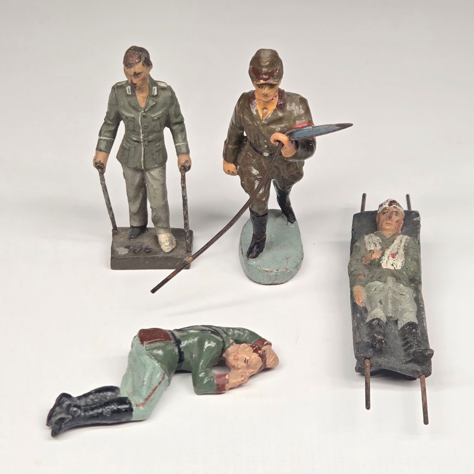 4) GERMAN LINEOL ELASTOLIN COMPOSITION SOLDIERS: ALL REMAIN IN FAIR TO GOOD CONDITION, SHOWING TYPICAL USAGE WEAR AS SHOWN. METAL SHOVEL HAS BEND IN HANDLE.