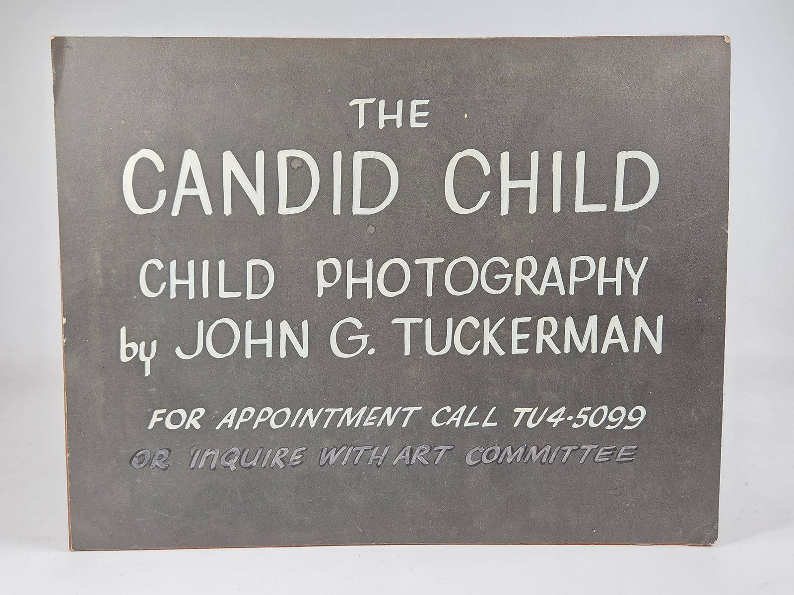 JOHN G. TUCKERMAN CANDID CHILD PHOTOGRAPHY SIGN: MASONITE SIGN REMAINS IN GOOD CONDITION, SHOWING SOME TYPICAL WEAR.