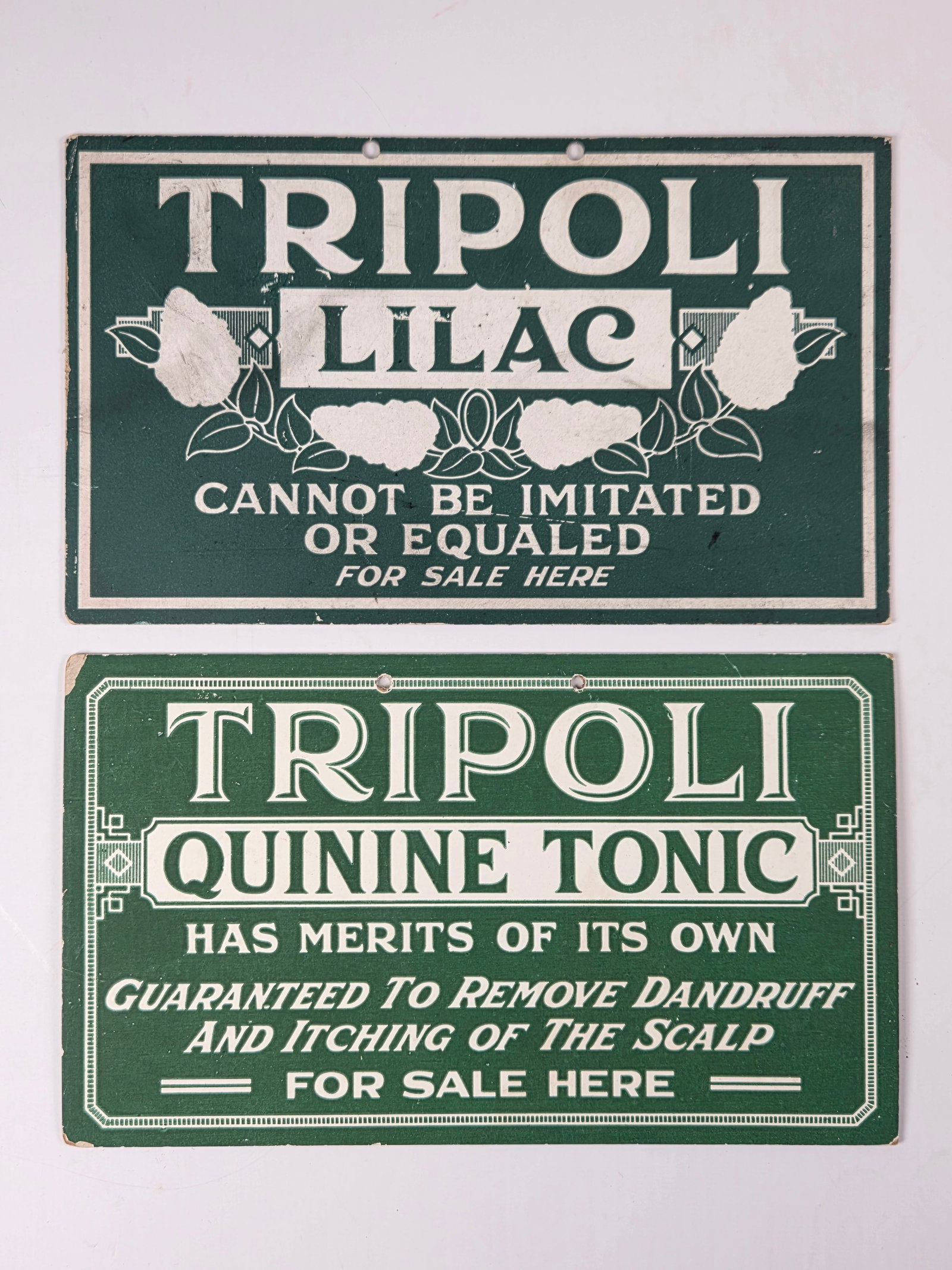 2) CARDBOARD TRIPOLI LILAC & TONIC SIGNS: BOTH REMAIN IN GOOD CONDITION, SHOWING SOME TYPICAL WEAR.