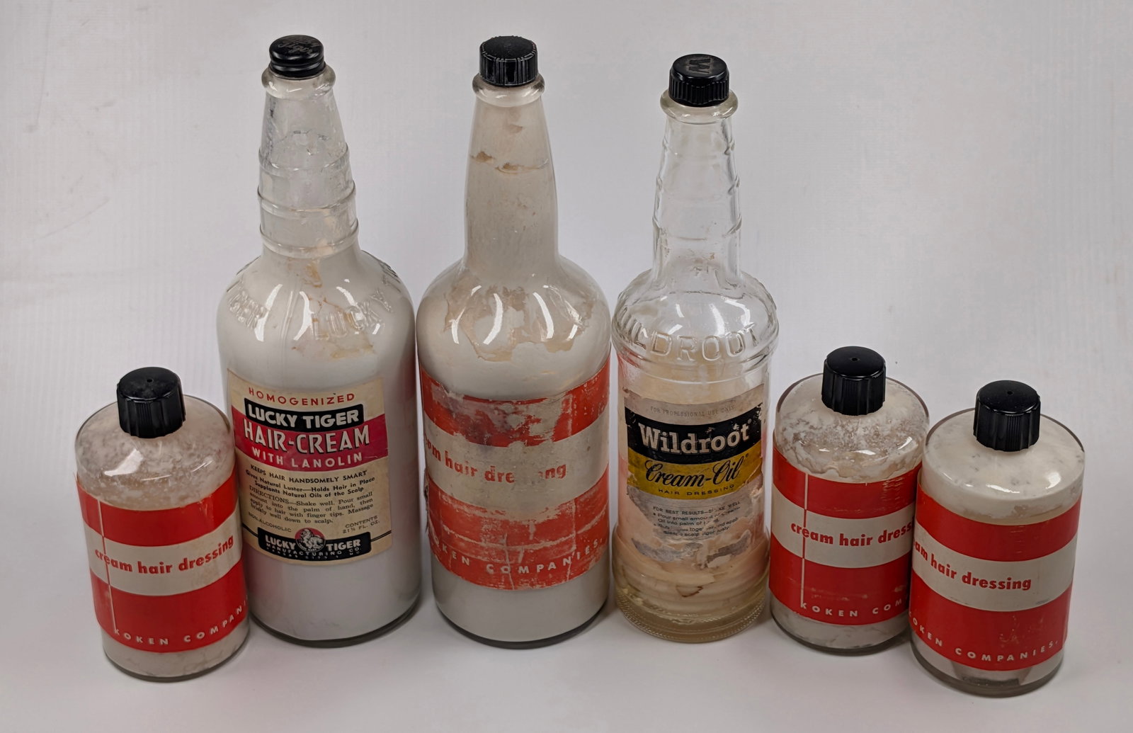 6) BARBER SHOP SUPPLY ADVERTISING GLASS BOTTLES: ALL REMAIN IN GOOD CONDITION, SHOWING SOME TYPICAL WEAR. HAIRDRESSING LARGE LABEL SHOWING WEAR THROUGHOUT, ALL OTHER LABELS REMAIN NICE.