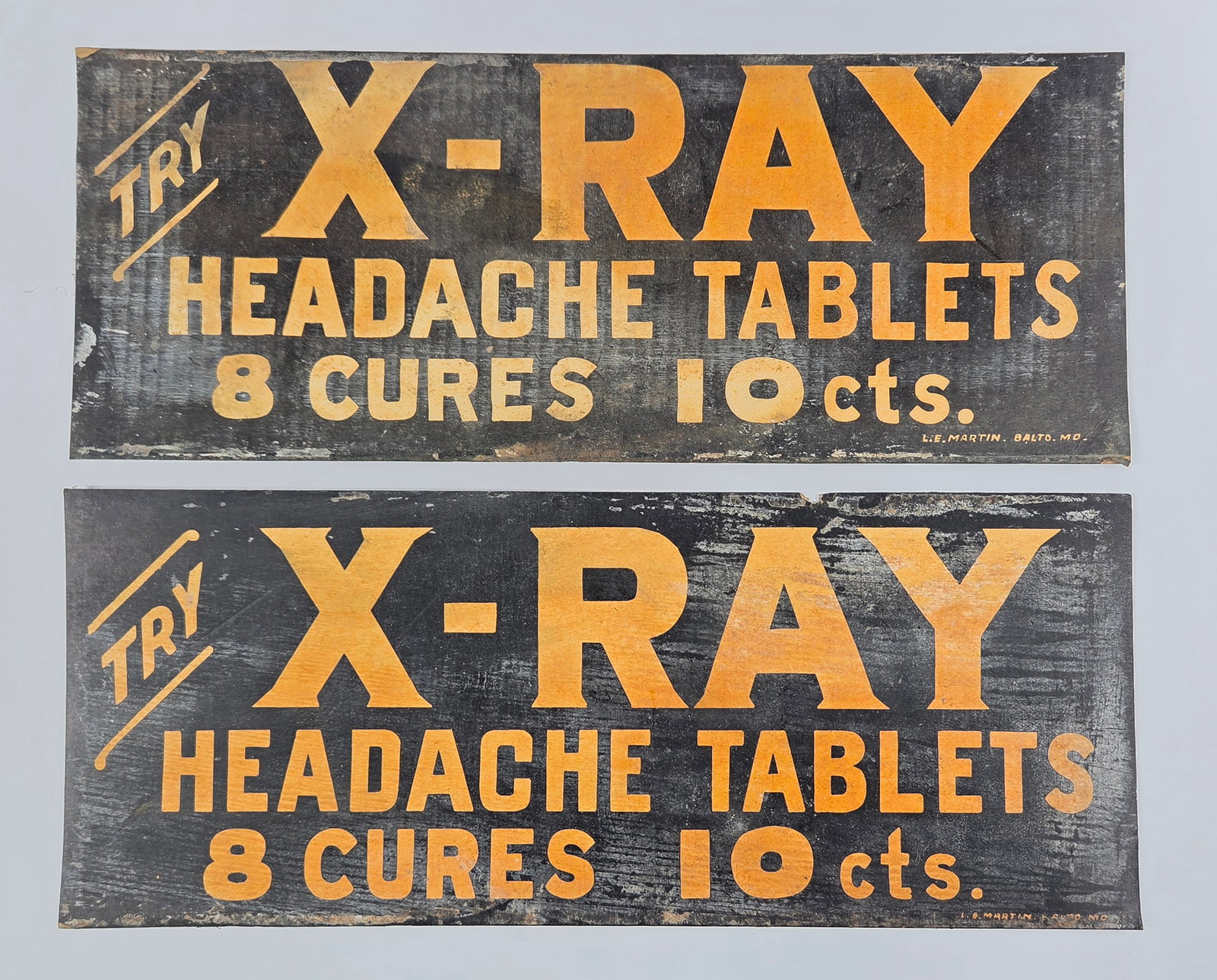 2) X-RAY HEADACHE TABLETS CARDBOARD SIGNS: BOTH REMAIN IN GOOD CONDITION, SHOWING TYPICAL USAGE WEAR.