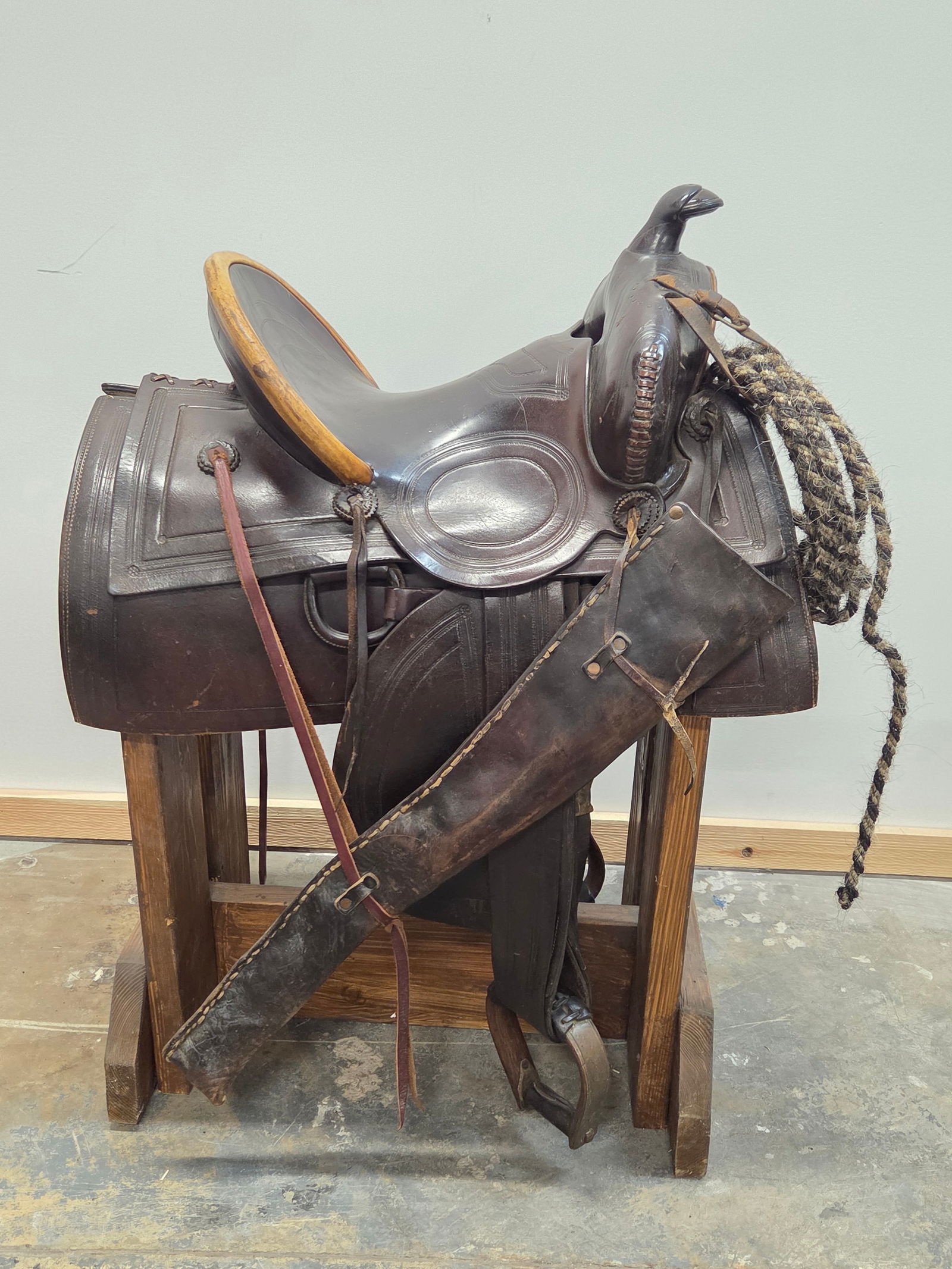 UNMARKED WESTERN LEATHER SADDLE: REMAINS IN GOOD CONDITION, SHOWING SOME TYPICAL WEAR. INCLUDES ALL AS SHOWS. STAND NOT INCLUDED.