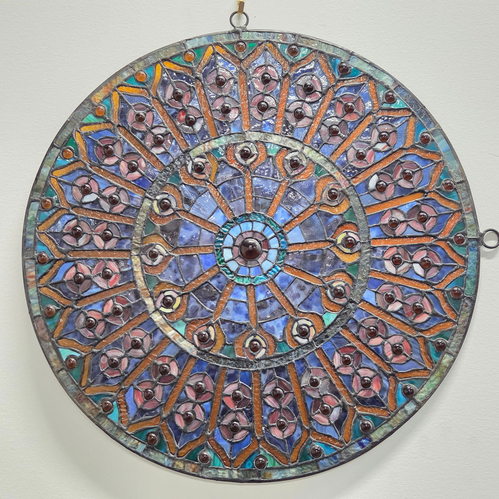 ROUND GEOMETRIC LEADED STAINED GLASS WINDOW: REMAINS IN GOOD CONDITION, SHOWING SOME TYPICAL WEAR.