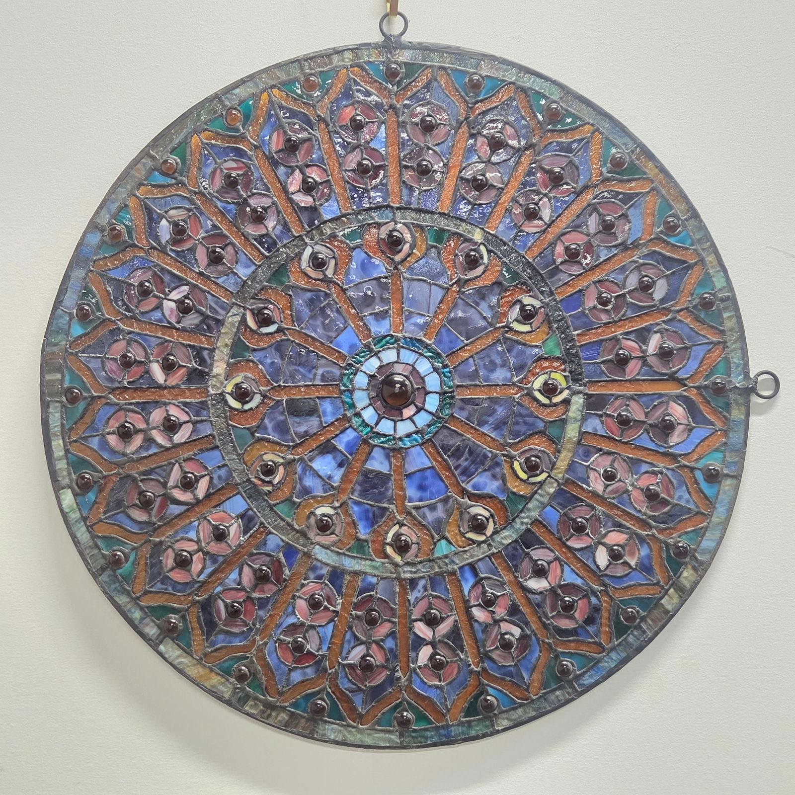 ROUND GEOMETRIC LEADED STAINED GLASS WINDOW: REMAINS IN GOOD CONDITION, SHOWING SOME TYPICAL WEAR.