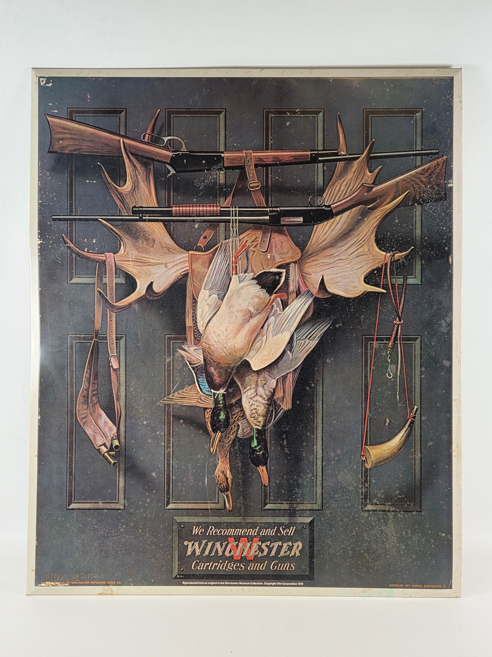 WINCHESTER CARTRIDGES & GUNS LITHO METAL SIGN: REMAINS IN GOOD CONDITION, SHOWING SOME SURFACE WEAR AND SLIGHT BENDING.