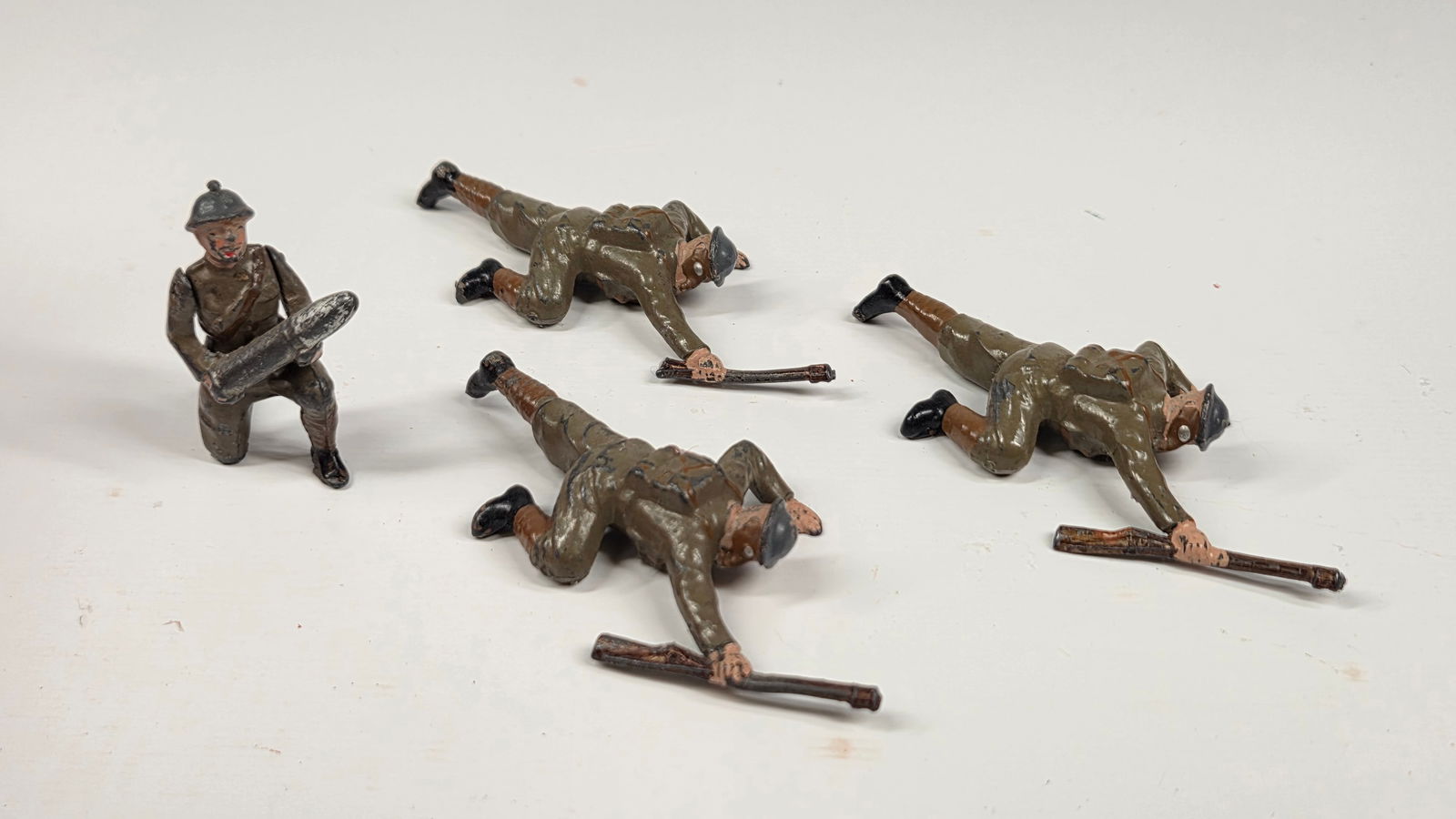 4) VINTAGE BRITAINS SOLDIERS IN ACTION: ALL REMAIN IN FAIR TO GOOD CONDITION, SHOWING SOME TYPICAL PAINT WEAR.