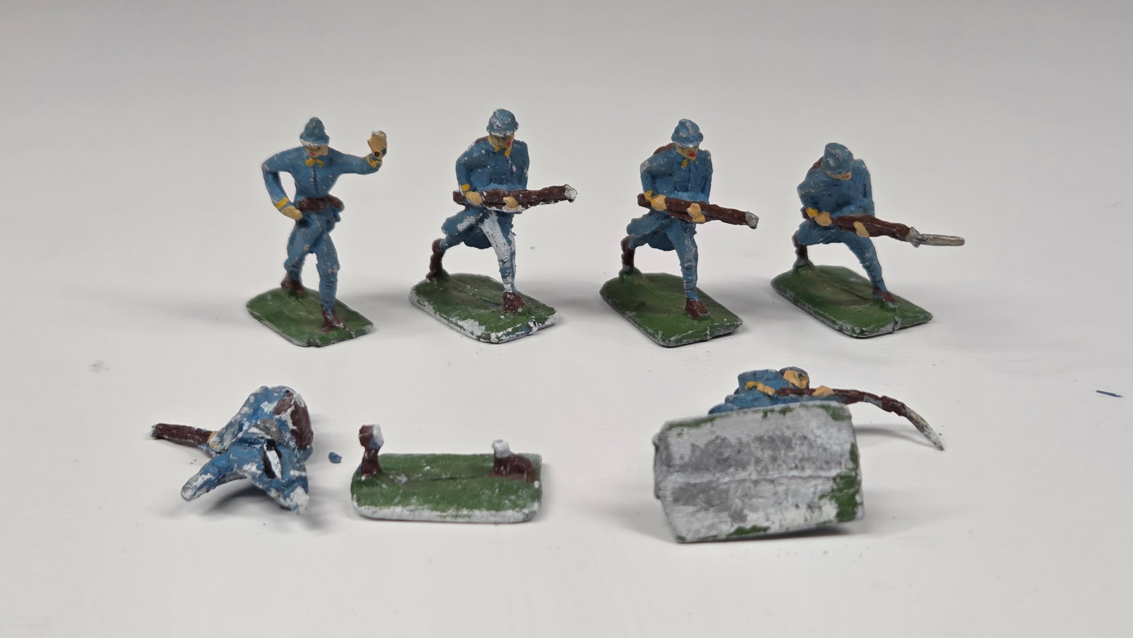 5) UNMARKED HAND PAINTED LEAD SOLDIERS: ALL REMAIN IN FAIR CONDITION, SHOWING PAINT WEAR. ALL WITH BENDS IN RIFLES. ONE FIGURE BROKEN OFF THE BASE.