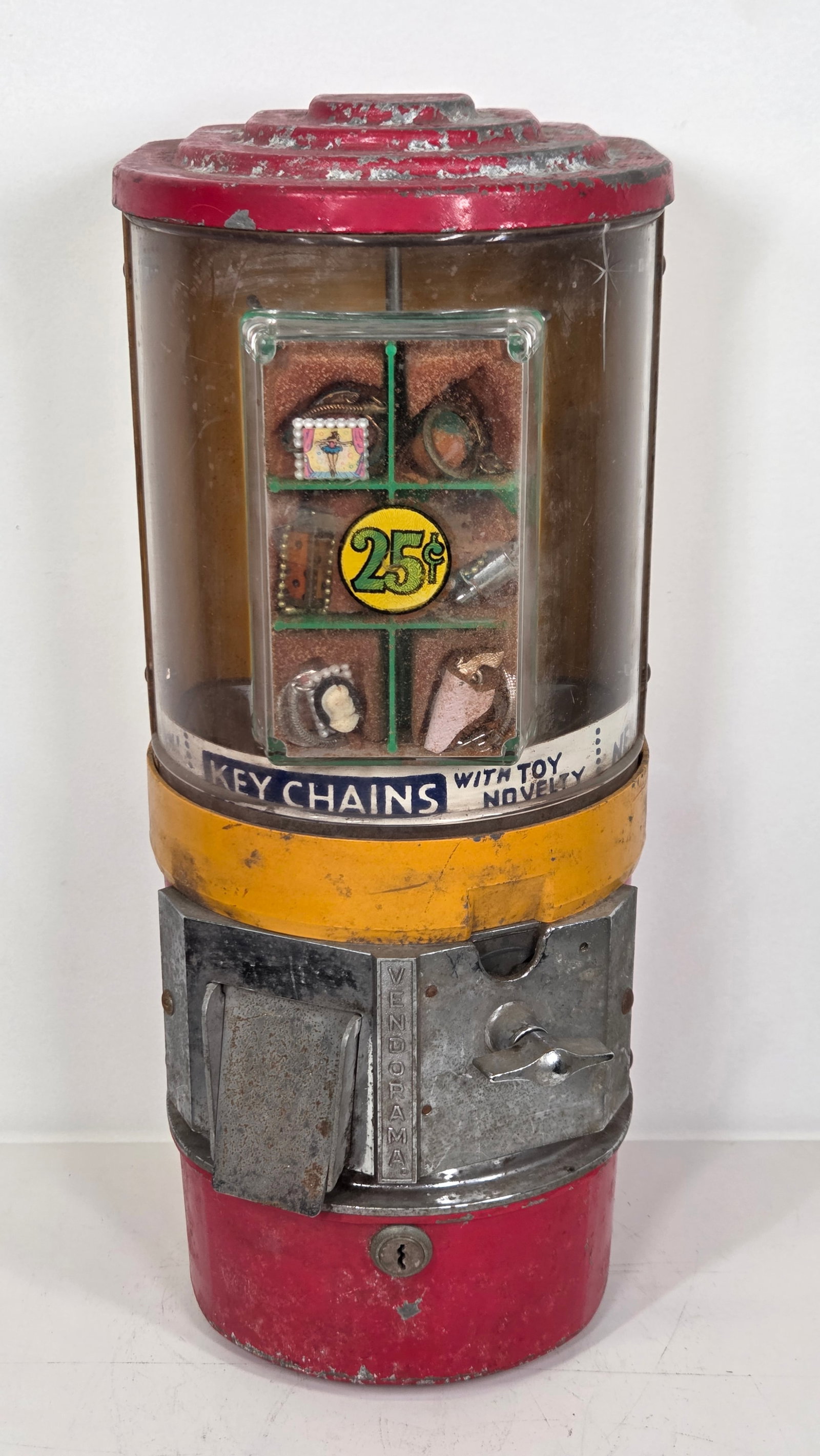 VINTAGE VENDORAMA KEYCHAIN CHARM VENDING MACHINE: REMAINS IN FAIR TO GOOD CONDITION, SHOWING USAGE WEAR THROUGHOUT.