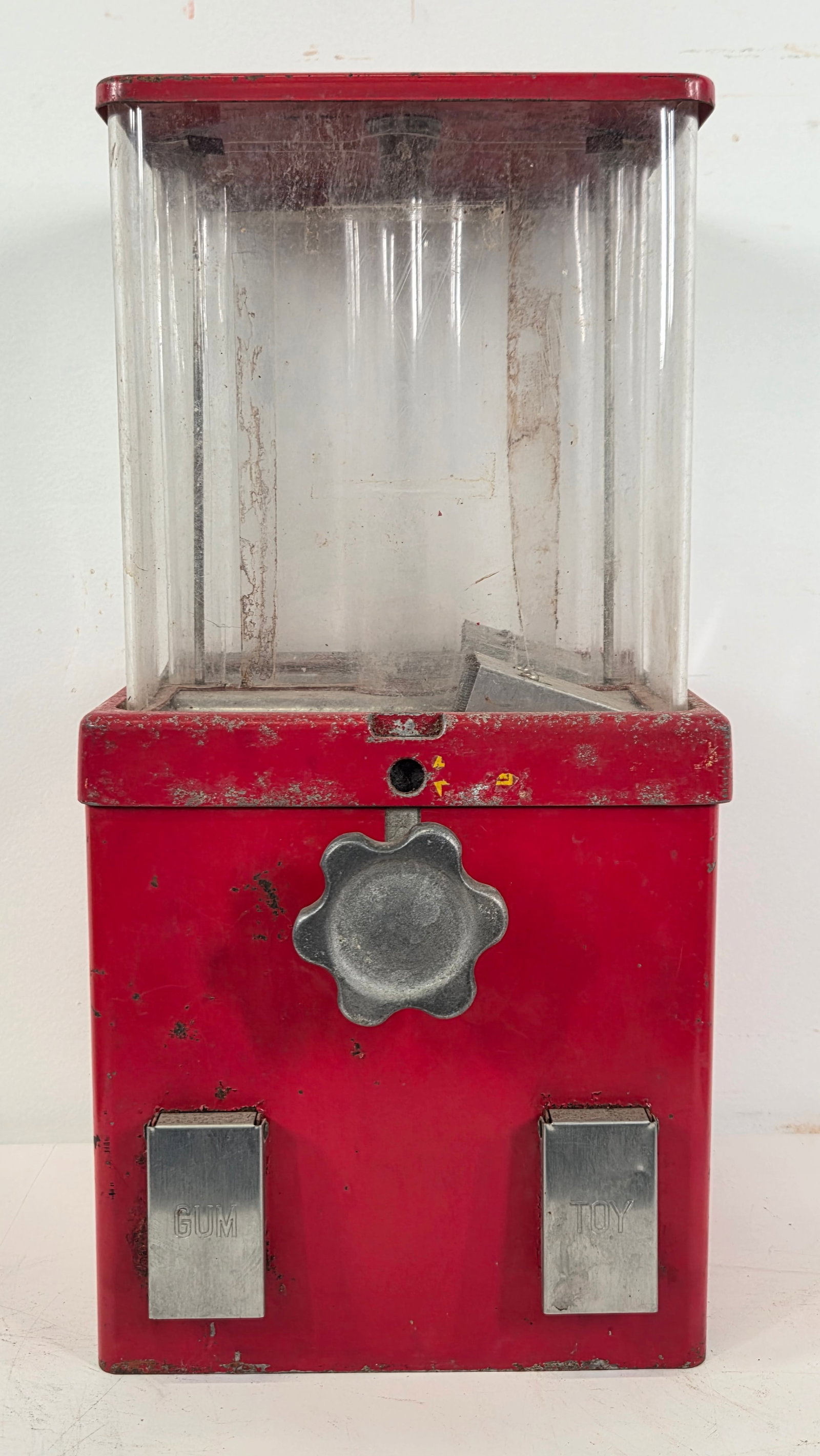 VINTAGE CRANK HANDLE GUM / TOY VENDING MACHINE: REMAINS IN POOR TO FAIR CONDITION, SHOWING WEAR THROUGHOUT. DIRTY, NEEDS CLEANED. LOCKING MECHANISM ON TOP IS BROKEN.