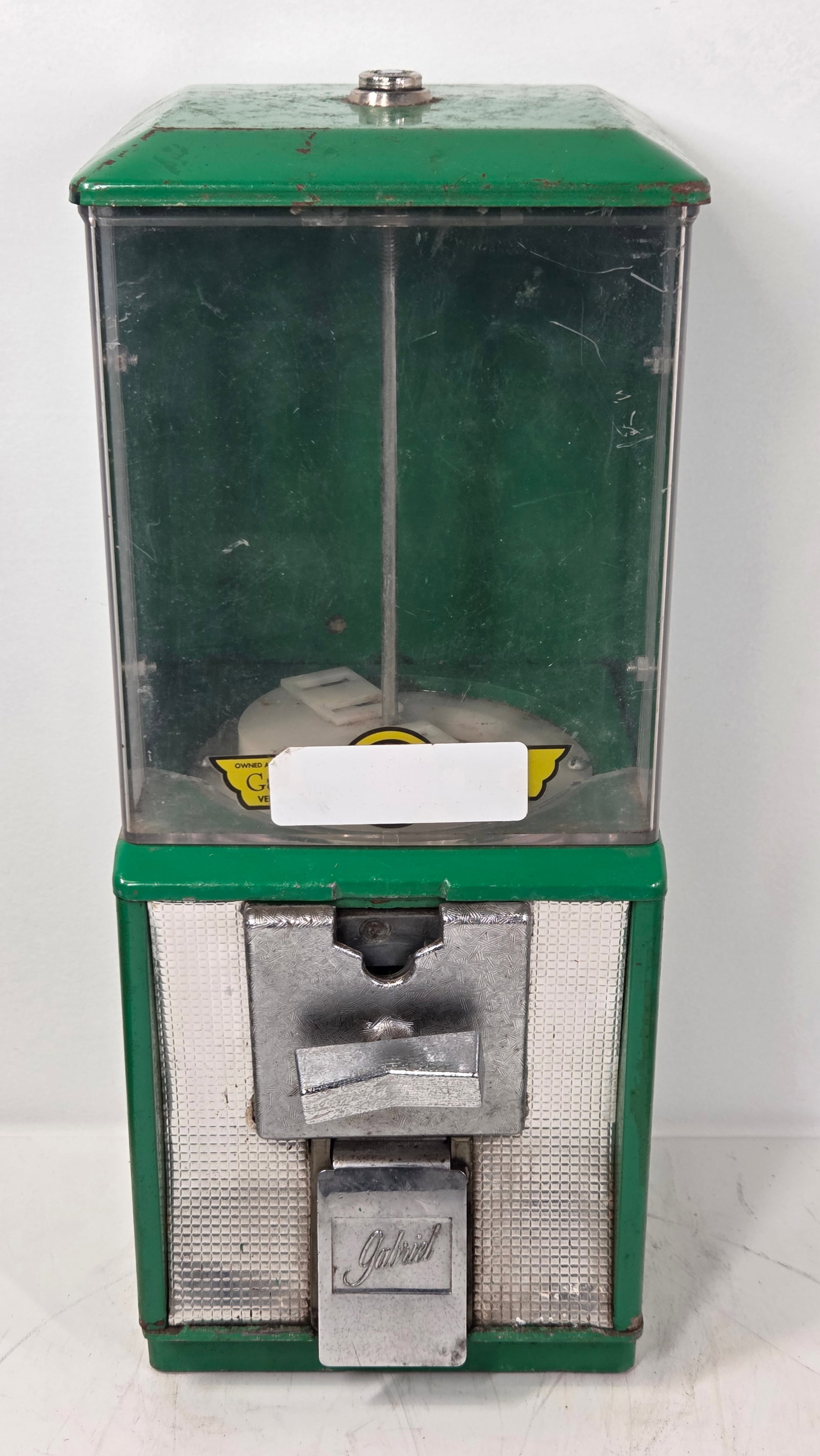 VINTAGE GREEN GABRIEL GUMBALL VENDING MACHINE: REMAINS IN FAIR TO GOOD CONDITION, SHOWING TYPICAL USAGE WEAR THROUGHOUT.