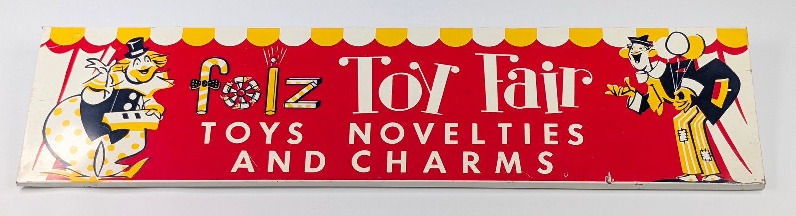 VINTAGE FOLZ TOY FAIR METAL SIGN: REMAINS IN VERY GOOD CONDITION, SHOWING ONLY LIGHT STORAGE WEAR.