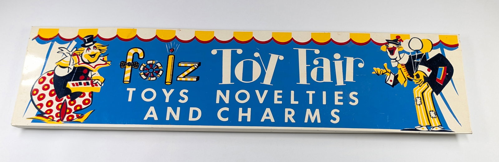 VINTAGE FOLZ TOY FAIR METAL SIGN: REMAINS IN VERY GOOD CONDITION, SHOWING ONLY SOME LIGHT STORAGE WEAR.