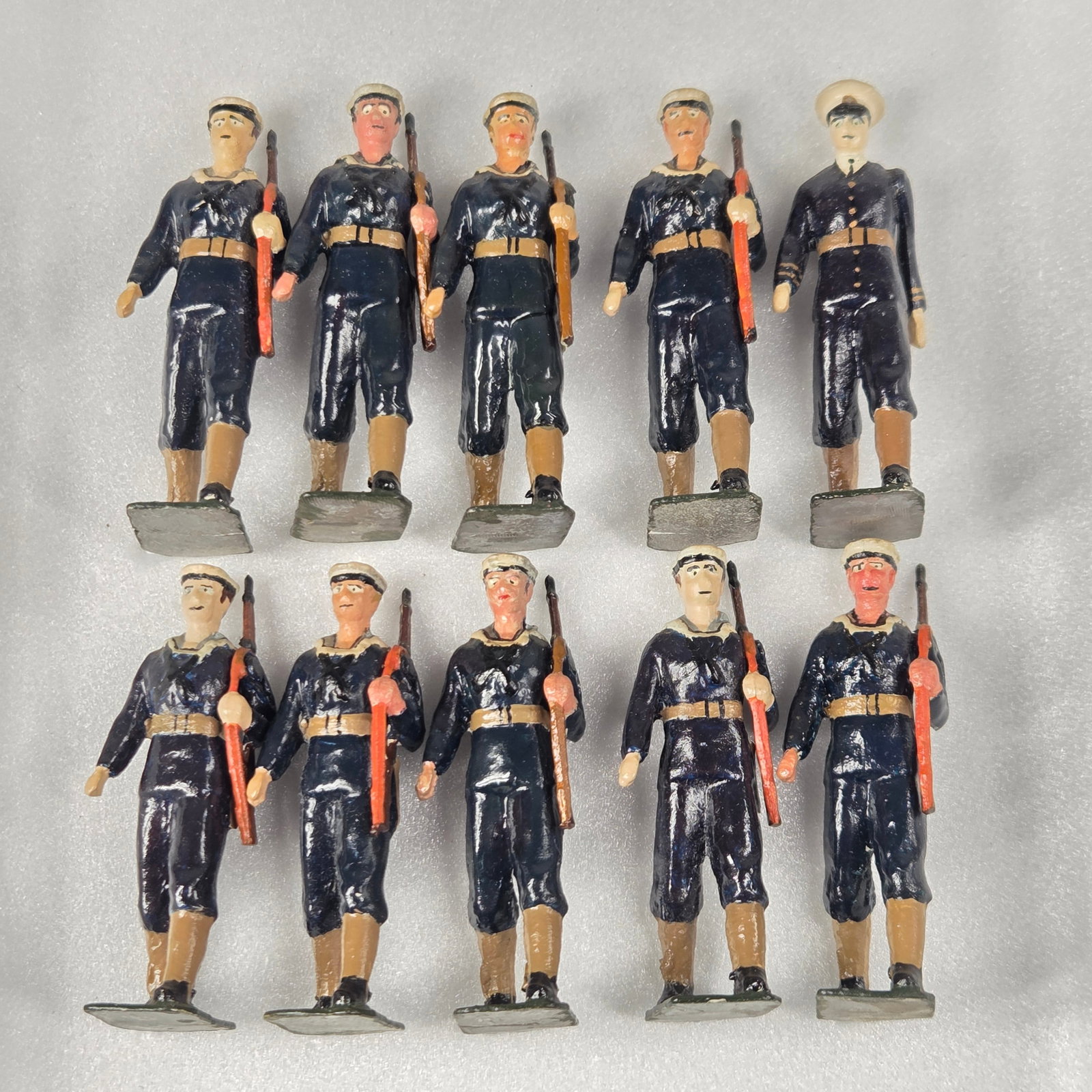 10) UNMARKED HAND PAINTED SAILORS W/ RIFLES: ALL REMAIN IN GOOD CONDITION, SHOWING SOME TYPICAL WEAR.