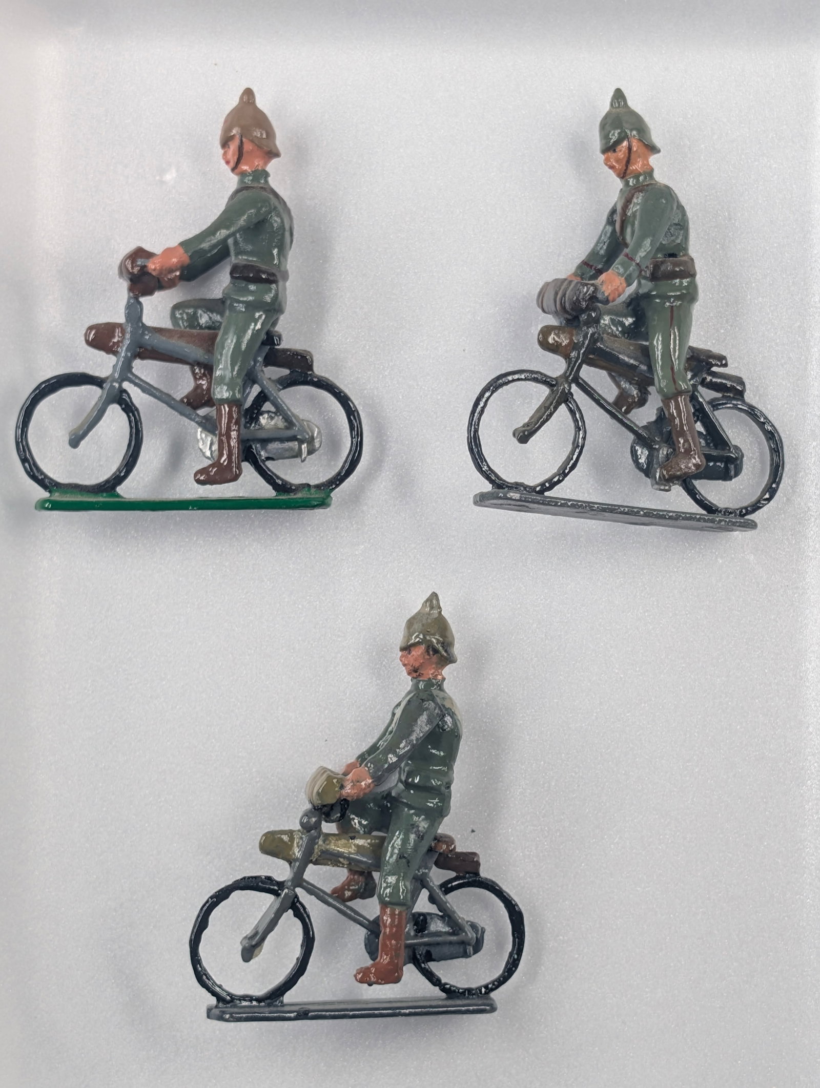 3) UNMARKED HAND PAINTED SOLDIERS ON BICYCLE: ALL REMAIN IN GOOD CONDITION, SHOWING SOME LIGHT TYPICAL WEAR.