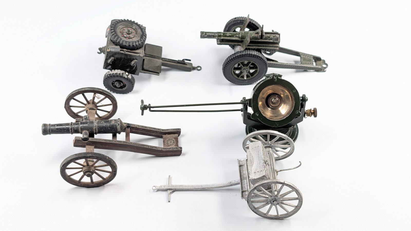 VARIOUS BRAND LEAD CANNONS, LIMBER TRAILERS, SEARCHLIGHT: ALL REMAIN IN FAIR TO GOOD CONDITION, SHOWING WEAR THROUGHOUT. BENDS AND PAINT WEAR.