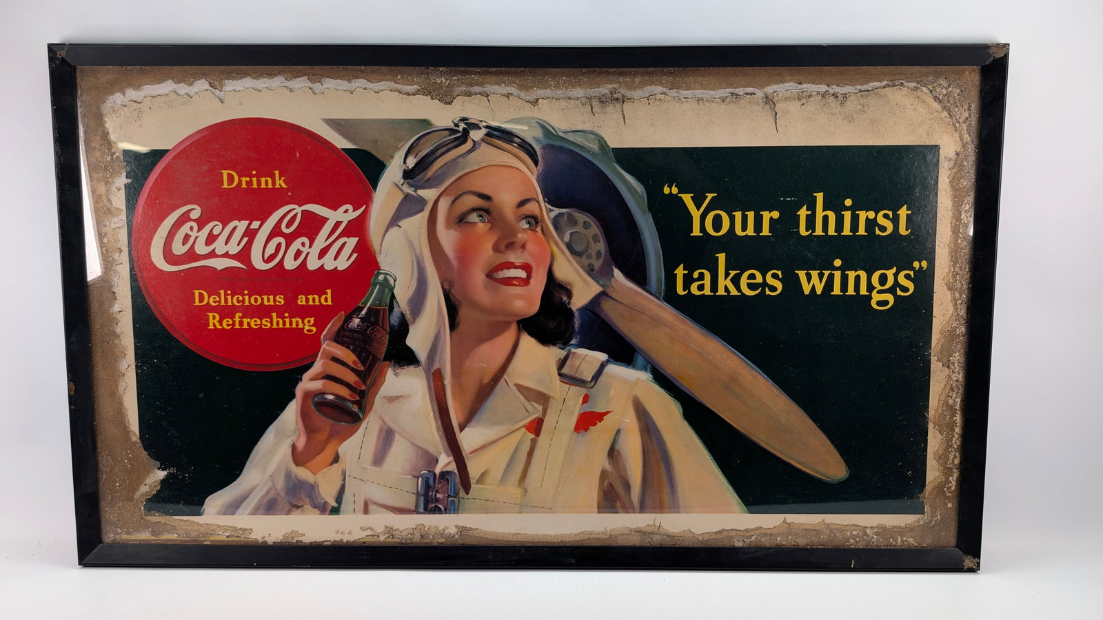 EARLY COCA COLA FEMALE PILOT AIRPLANE CARDBOARD SIGN: REMAINS IN POOR CONDITION, SHOWING DAMAGE THROUGHOUT THE ENTIRE EDGE. SHOWING WATER DAMAGE.