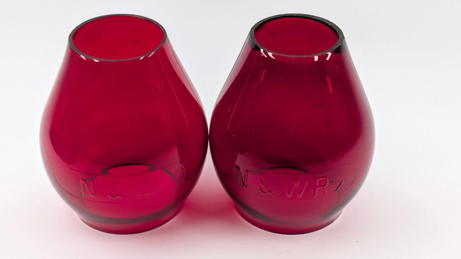2) RUBY RED NORFOLK & WESTERN RAILROAD LANTERN GLOBES: BOTH REMAIN IN GOOD CONDITION, SHOWING SOME LIGHT TYPICAL WEAR.