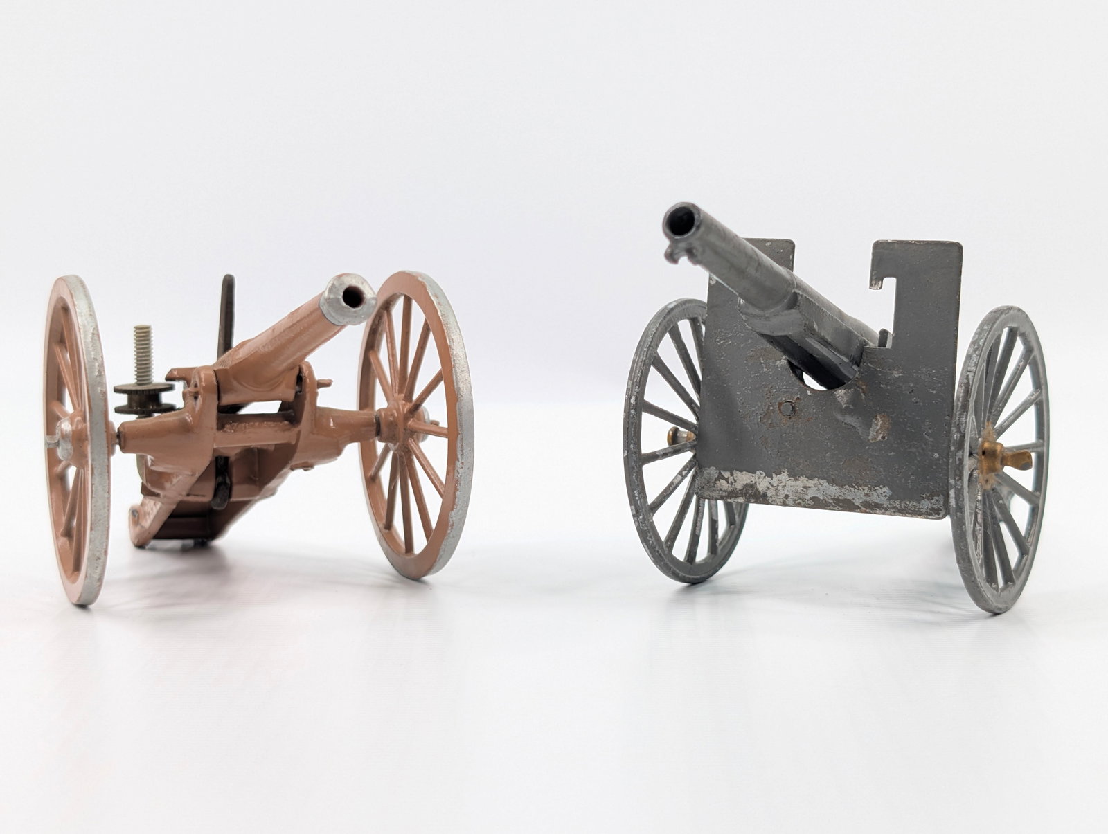 2) VINTAGE BRITAIN MILITARY CANNONS: BOTH REMAIN IN GOOD CONDITION, SHOWING SOME TYPICAL WEAR. TAN ONE REPAINTED.