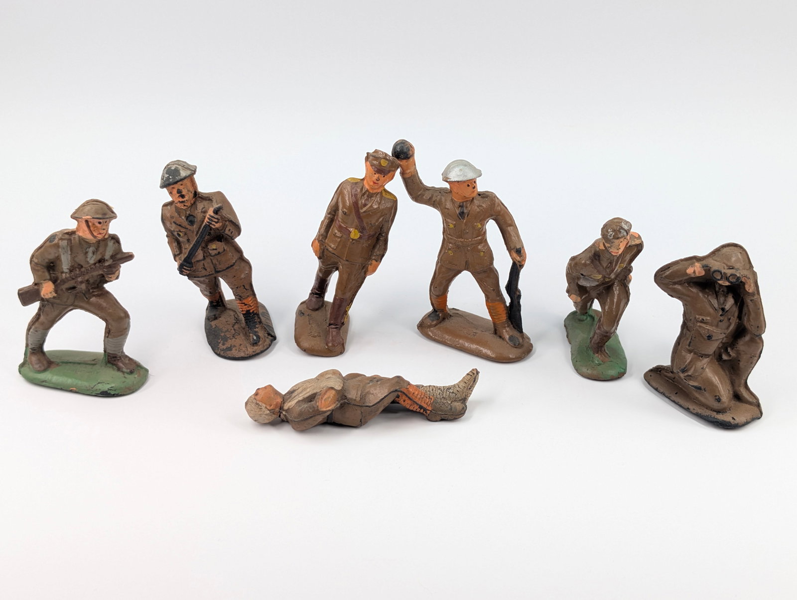 7) VINTAGE RUBBER MILITARY SOLDIERS: ALL REMAIN IN FAIR TO GOOD CONDITION, SHOWING SOME BENDS AND PAINT WEAR.