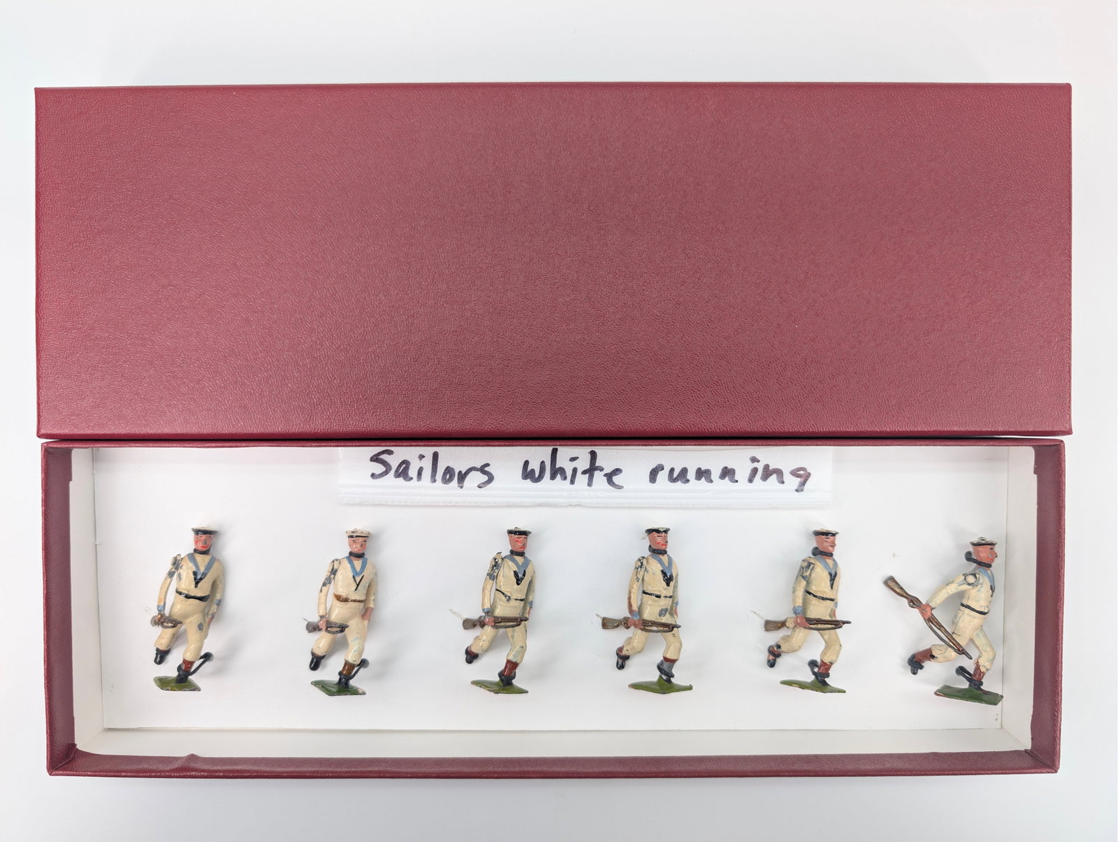 SET OF 6 VINTAGE BRITAIN SAILORS IN WHITE RUNNING: ALL REMAIN IN FAIR TO GOOD CONDITION, SHOWING PAINT WEAR. CUSTOM BOX.